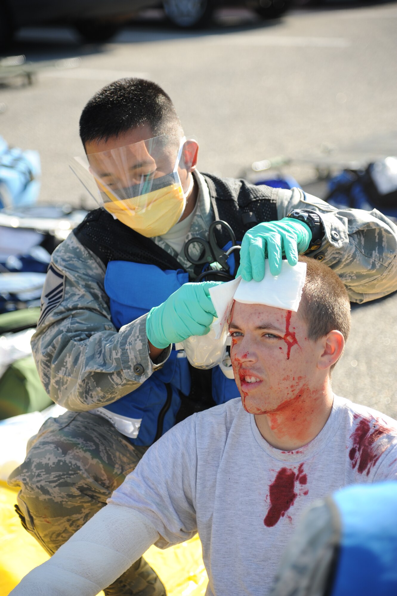 Master Sgt. Jerry Dameron, 81st Aerospace Medicine Squadron, administers medical treatment on an injured “victim,” Airman 1st Class James Meyers, 336th Training Squadron during a hazardous material and major accident response exercise Oct. 31, 2012, at Hangar 4, Keesler Air Force Base, Miss.  The exercise scenario consisted of a group of Airmen cleaning inside the hangar in preparation for demolition when a shelf holding old munitions fell to the ground causing one to break open, explode and splash an “oily substance” on several of the “victims.”  The exercise helped prepare first responders in the event of a real-world incident.  (U.S. Air Force photo by Kemberly Groue)