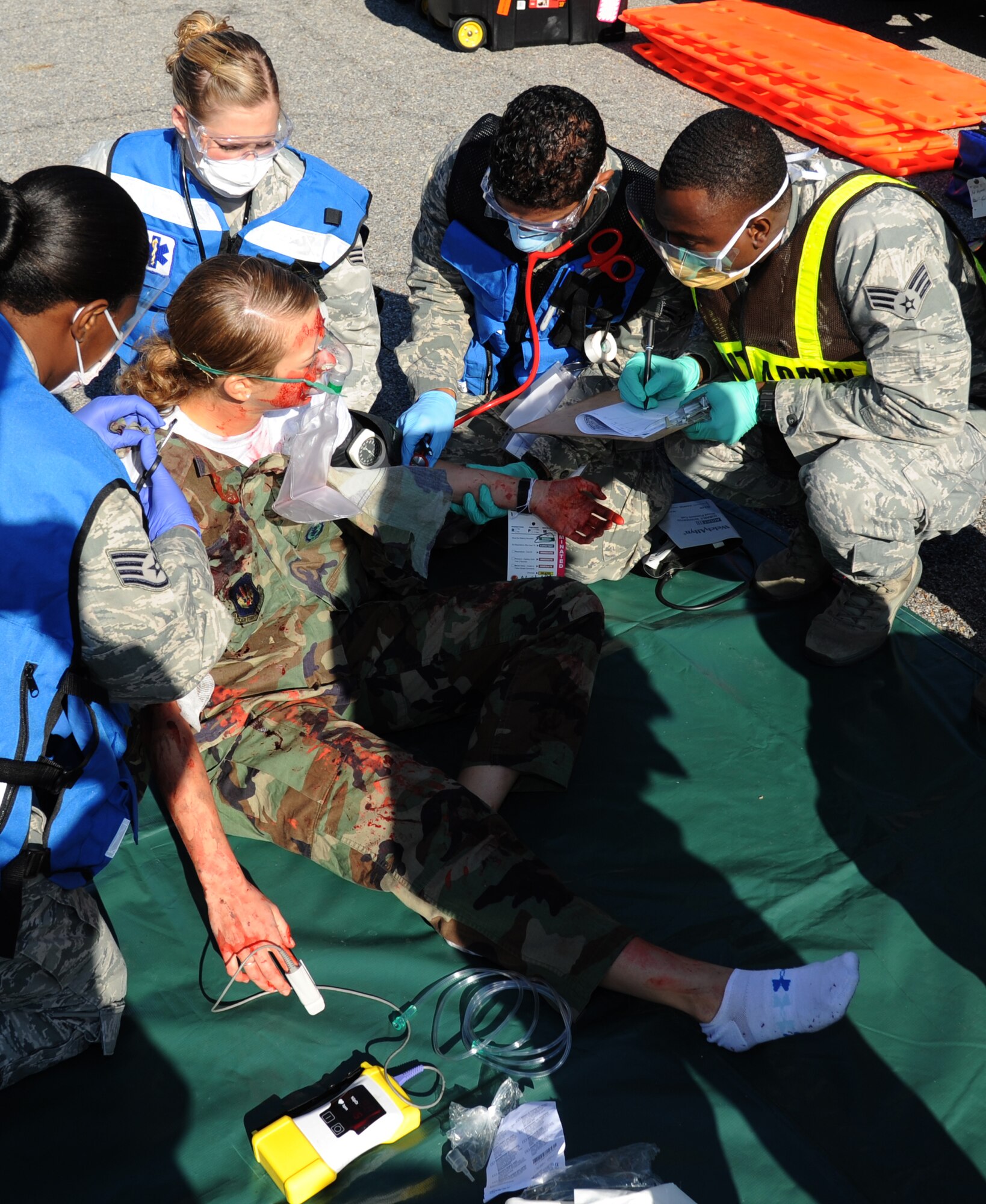 Airman 1st Class Sarah Kenny, 336th Training Squadron, portrays a “victim” receiving medical treatment by members of the 81st Medical Group during a hazardous material and major accident response exercise Oct. 31, 2012, at Hangar 4, Keesler Air Force Base, Miss.  The exercise scenario consisted of a group of Airmen cleaning inside the hangar in preparation for demolition when a shelf holding old munitions fell to the ground causing one to break open, explode and splash an “oily substance” on several of the “victims.”  The exercise helped prepare first responders in the event of a real-world incident.  (U.S. Air Force photo by Kemberly Groue)