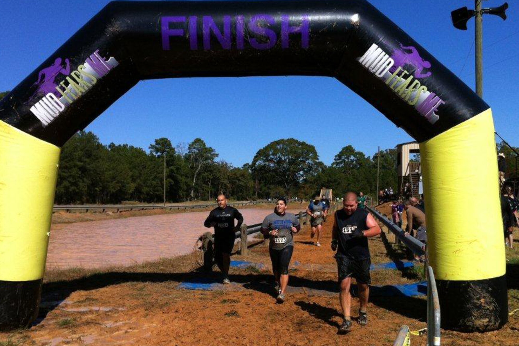 (L-R) Mark Geer and Andrea Amburn, 307th Bomb Wing members, cross the finish line of the “Mud Fears Me” obstacle race in Shreveport, La., Oct. 27, 2012. The event is a fun 3.1 mile / 20 + obstacle course race designed to test all around strength, stamina, mental grit, and camaraderie. Participants were forced to overcome numerous obstacles such as the Ladder to Success, Mud Dunk, Silverback Swing, Walk of Shame, Torment Trenches, Over/Under Dare, Pit of Pain, the Belly Bog and the Cargo Climb, just to name a few. The event was held to raise money for “Child Help” that benefits abused children and other local charities. (Courtesy photo/Released) 