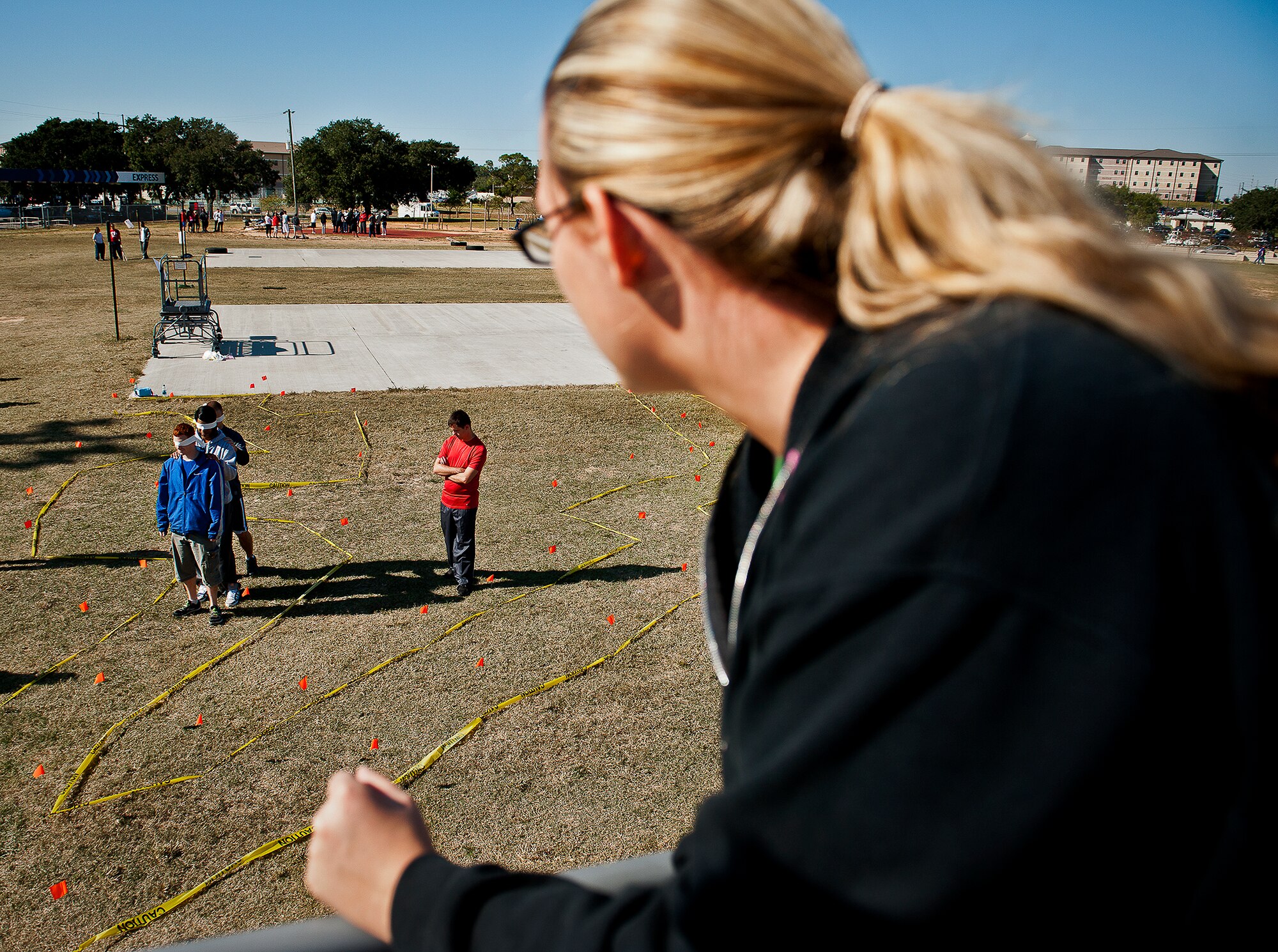 An Airman directs her blindfolded team through a maze from a platform above the course at the 96th Test Wing’s Wingman Day event Oct. 31 at Eglin Air Force Base, Fla.  Hundreds of Airmen and civilians participated in physical and non-physical challenges highlighting teamwork and resiliency.  (U.S. Air Force photo/Samuel King Jr.)