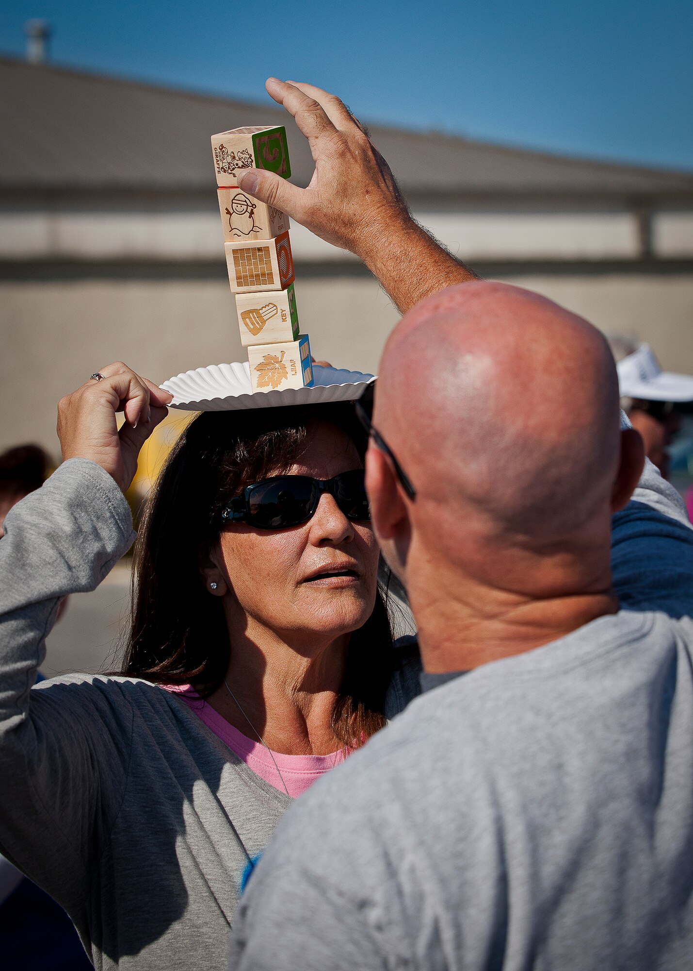 A civilian tries to balance five blocks on his partner’s head for more than two seconds at the 96th Test Wing’s Wingman Day event Oct. 31 at Eglin Air Force Base, Fla.  Hundreds of Airmen and civilians participated in physical and non-physical challenges highlighting teamwork and resiliency.  (U.S. Air Force photo/Samuel King Jr.)