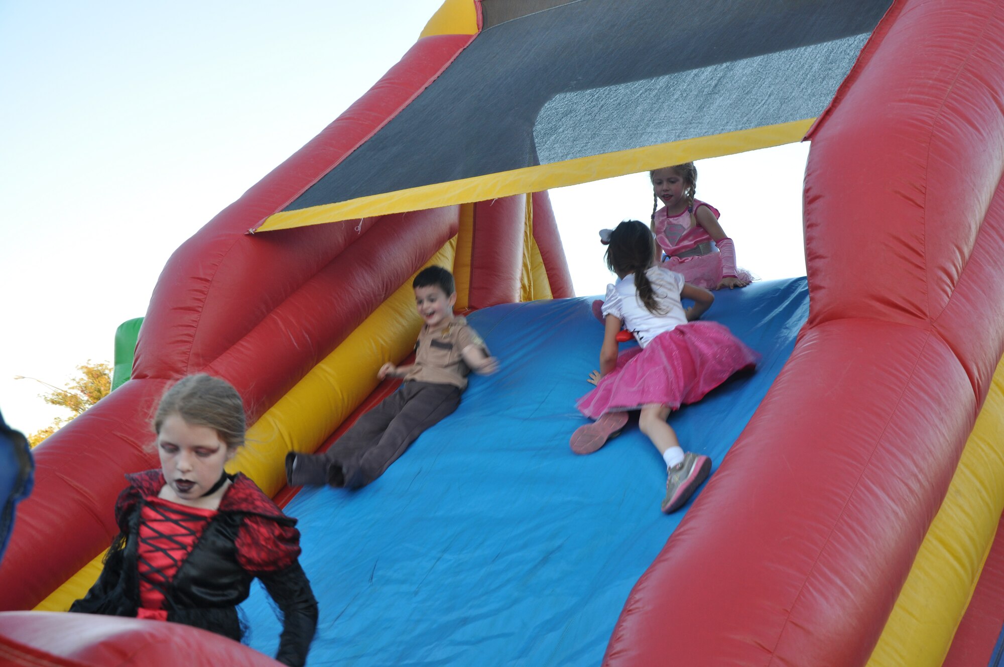GOODFELLOW AIR FORCE BASE, Texas – A group of children play on an inflatable obstacle course at the Base Theater parking lot here Oct. 31. The obstacle course and a bounce house were set up for the Halloween Trunk or Treat event. (U.S. Air Force photo/ Airman 1st Class Erica Rodriguez)