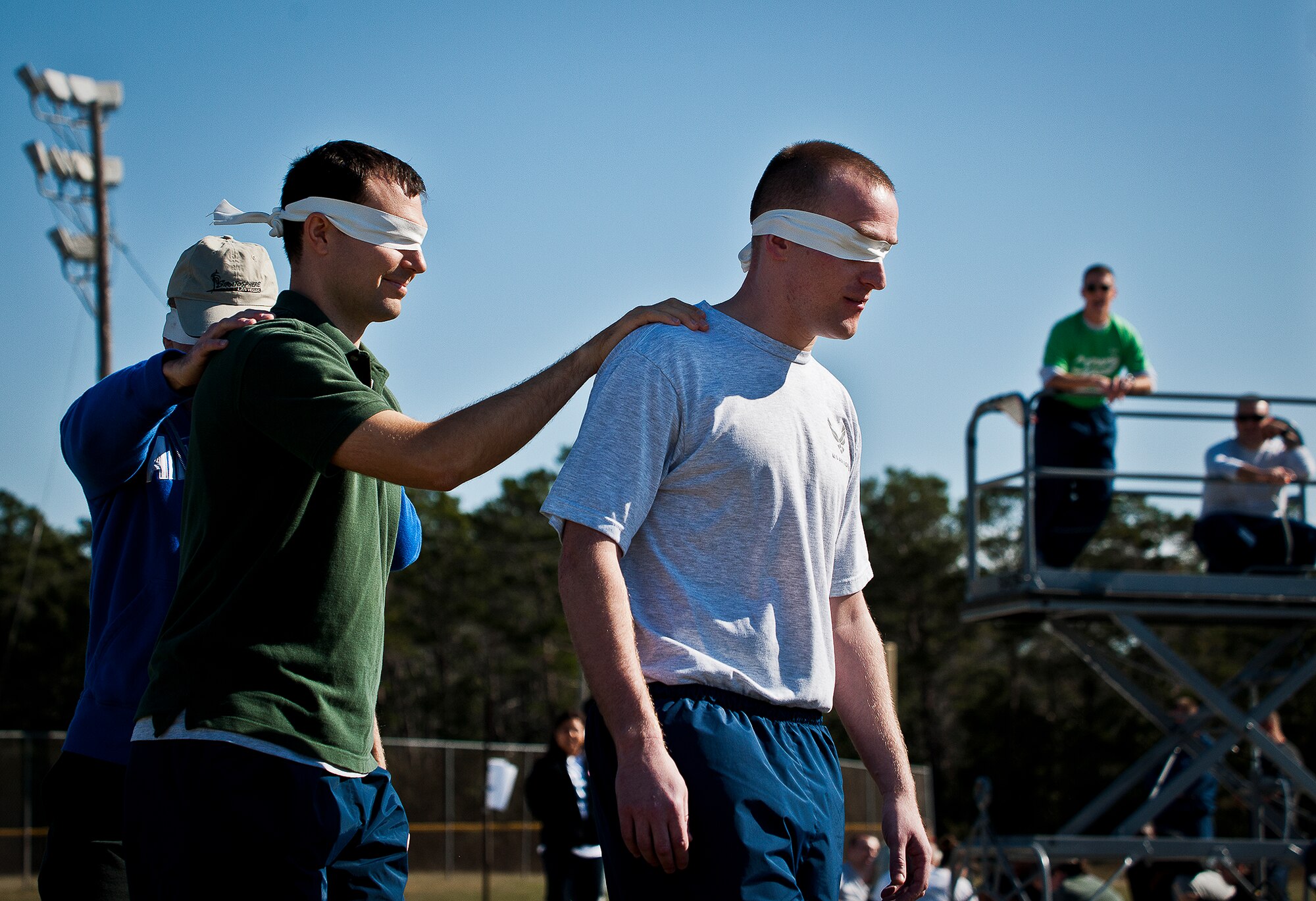 Blindfolded Airmen slowly move through a maze as an Airman gives them direction them from above during the 96th Test Wing’s Wingman Day event Oct. 31 at Eglin Air Force Base, Fla.  Hundreds of Airmen and civilians participated in physical and non-physical challenges highlighting teamwork and resiliency.  (U.S. Air Force photo/Samuel King Jr.)