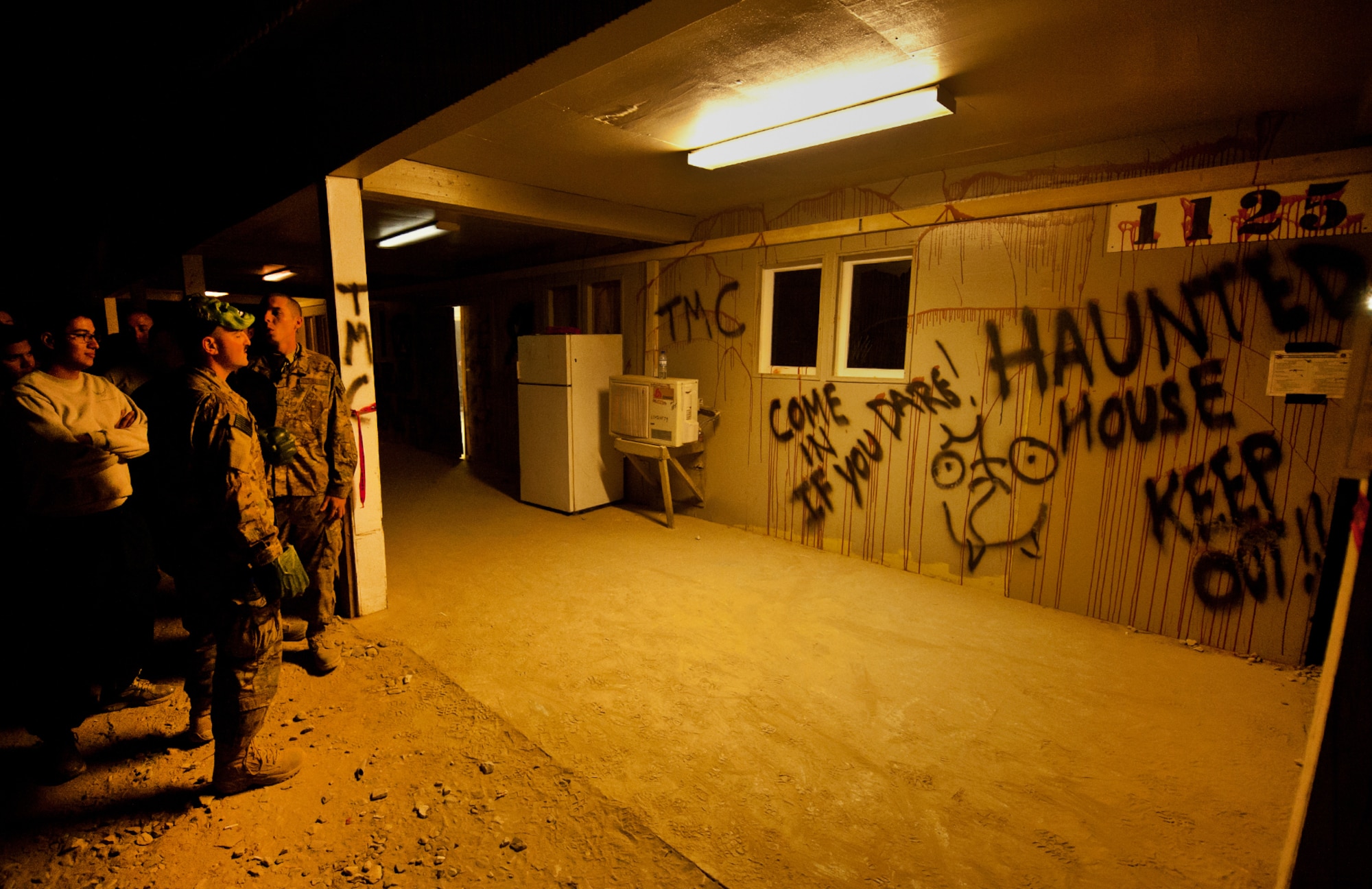 Personnel wait in line before entering a “haunted house” at Bagram Airfield, Afghanistan, Oct. 31, 2012. U. S. Army, Air Force, and DoD civilians volunteered for three weeks to prepare the house. “The haunted house” was open for six evenings. More than 300 people showed up to enjoy their spare time or duties at the house each night. (U.S. Air Force photo/Staff Sgt. Jeff Nevison)