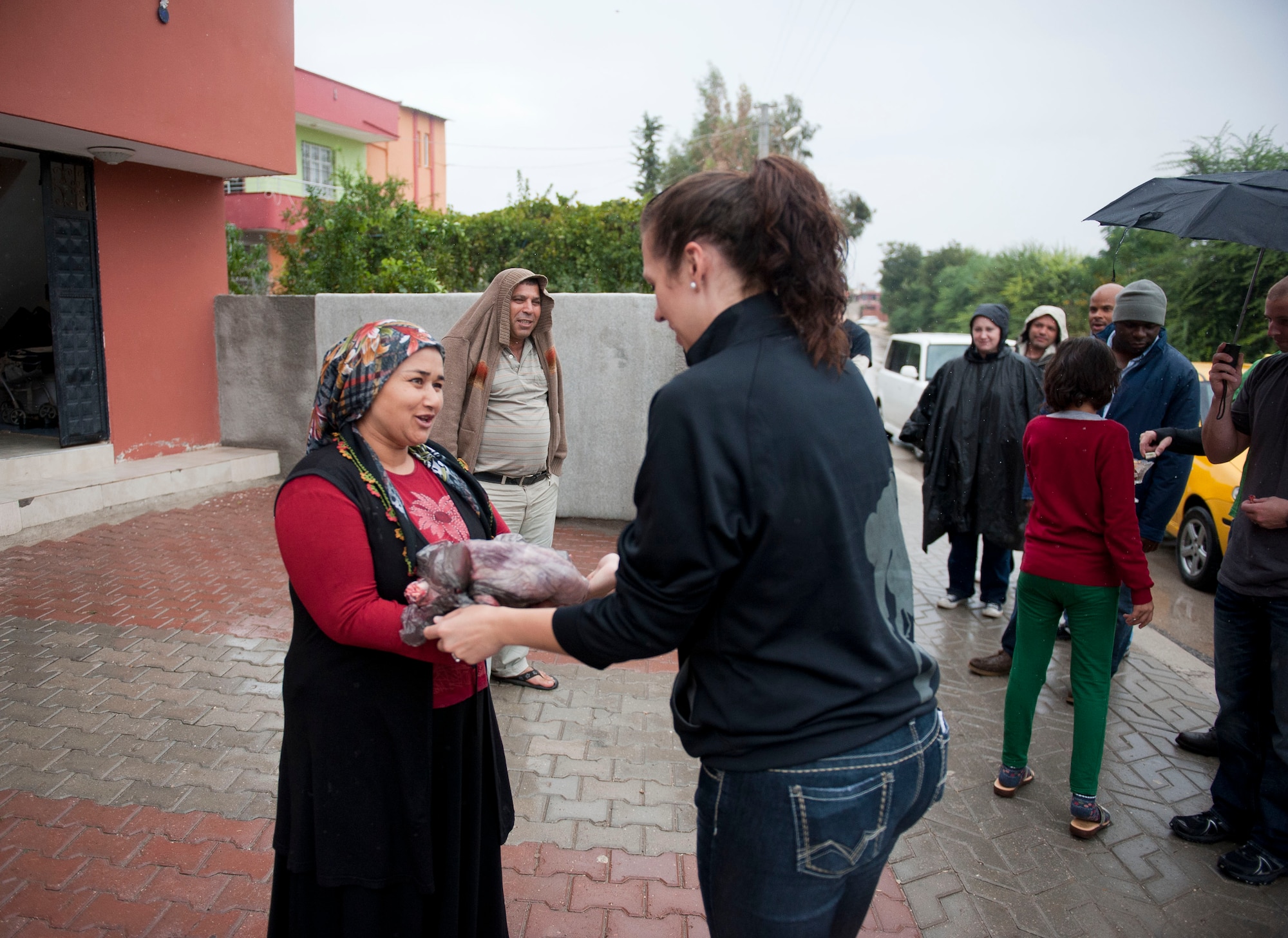 Senior Airman Michelle Horter, 90th Expeditionary Air Refueling Squadron, gives meat from a sacrificed sheep to a local Turkish family Oct. 25, 2012, at Incirlik Village, Turkey. This was the first time many local shop owners saw Americans participating in the Muslim Feast of Sacrifice holiday, or Kurban Bayrami, part of which includes charitable practices by helping those in need. (U.S. Air Force photos by Senior Airman Clayton Lenhardt/Released)