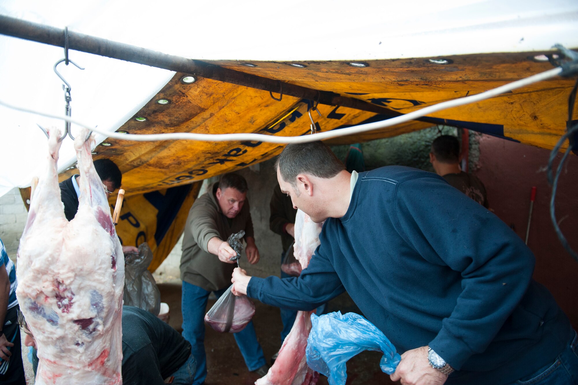 Senior Master Sgt. Richard Tigges and Lt. Col. Mike Moeding, 90th Expeditionary Air Refueling Squadron, bag meat from a sacrificed sheep Oct. 25, 2012, at Incirlik Village, Turkey. During the Muslim Feast of Sacrifice holiday, or Kurban Bayrami, sacrificing an animal is a symbolic way of thanking God for favors throughout the year. (U.S. Air Force photos by Senior Airman Clayton Lenhardt/Released)