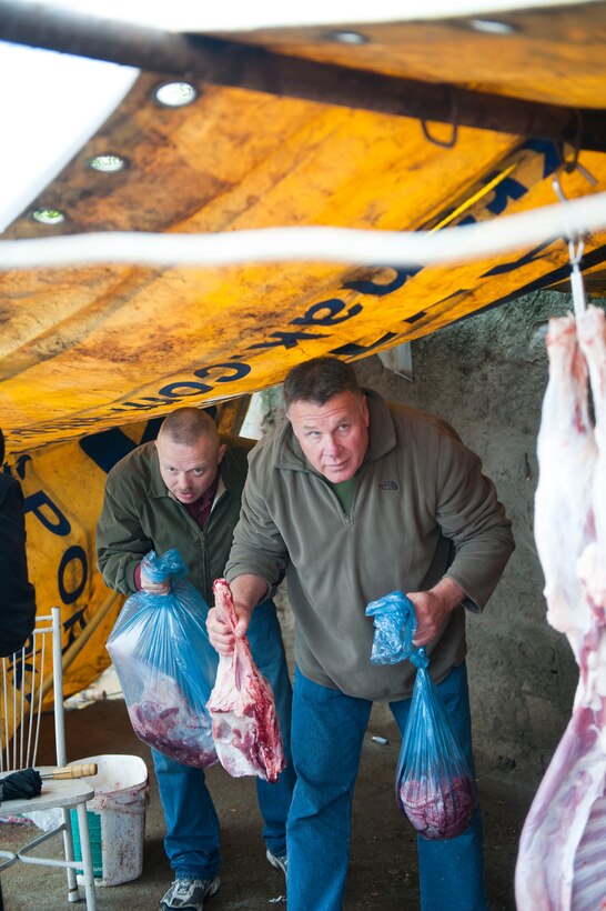 Chief Master Sgt. Richard Dawson, left, and Senior Master Sgt. Richard Tigges, 90th Expeditionary Air Refueling Squadron, bag meat from a sacrificed sheep Oct. 25, 2012, at Incirlik Village, Turkey. During the Muslim Feast of Sacrifice holiday, or Kurban Bayrami, sacrificing an animal is a symbolic way of thanking God for favors throughout the year. (U.S. Air Force photos by Senior Airman Clayton Lenhardt/Released)