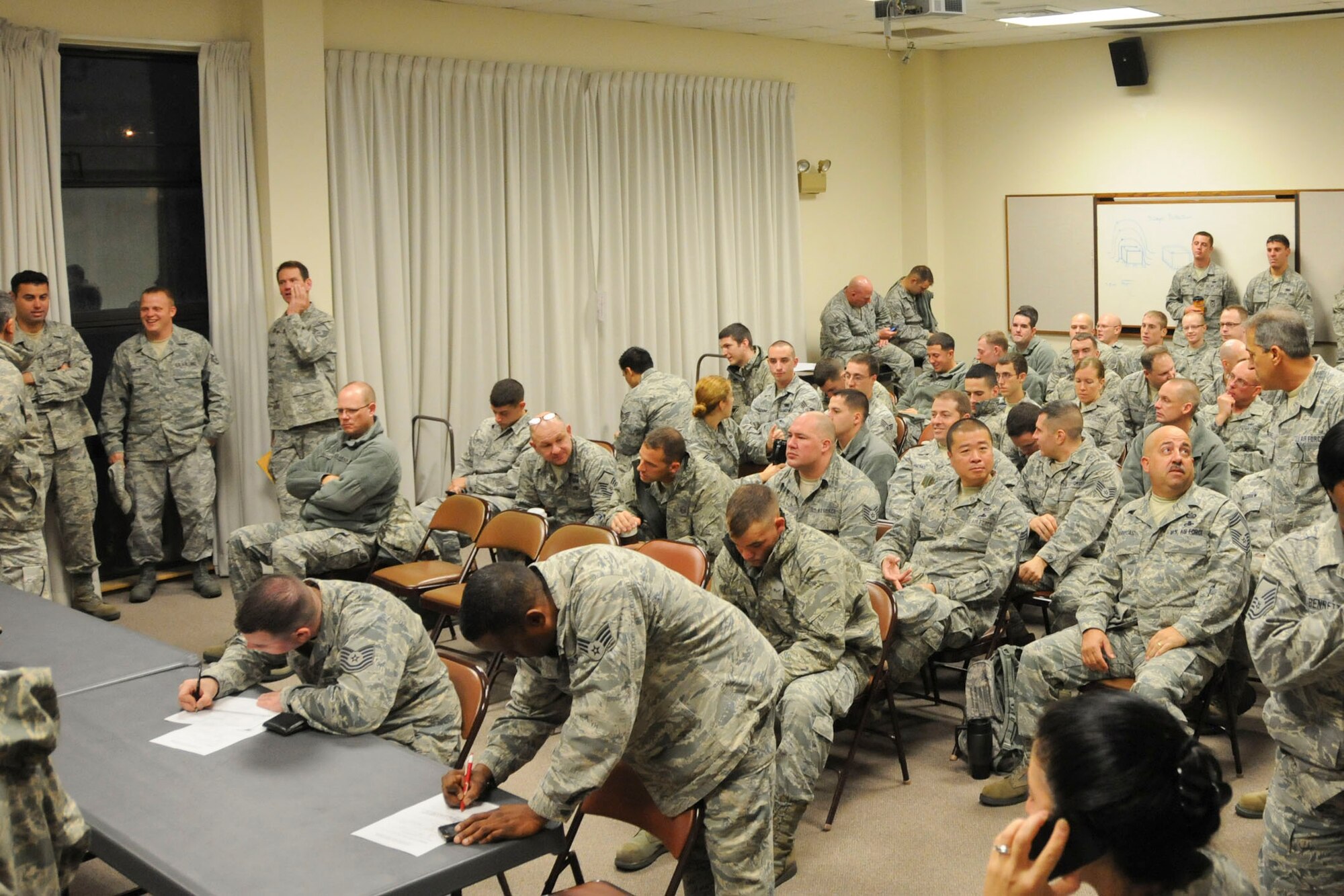 Members from critical agencies of the 102nd Intelligence Wing, Massachusetts Air National Guard, sign-in and await assignments October 29, 2012 on Otis Air National Guard Base. The airmen were activated to serve as assets to Task Force Patriot. The task force provided a structure for the Massachusetts National Guard to prepare for Hurricane Sandy, assist citizens during the storm, and help with a variety of tasks after the storm. (National Guard photo by Master Sgt. Aaron Smith/Released)