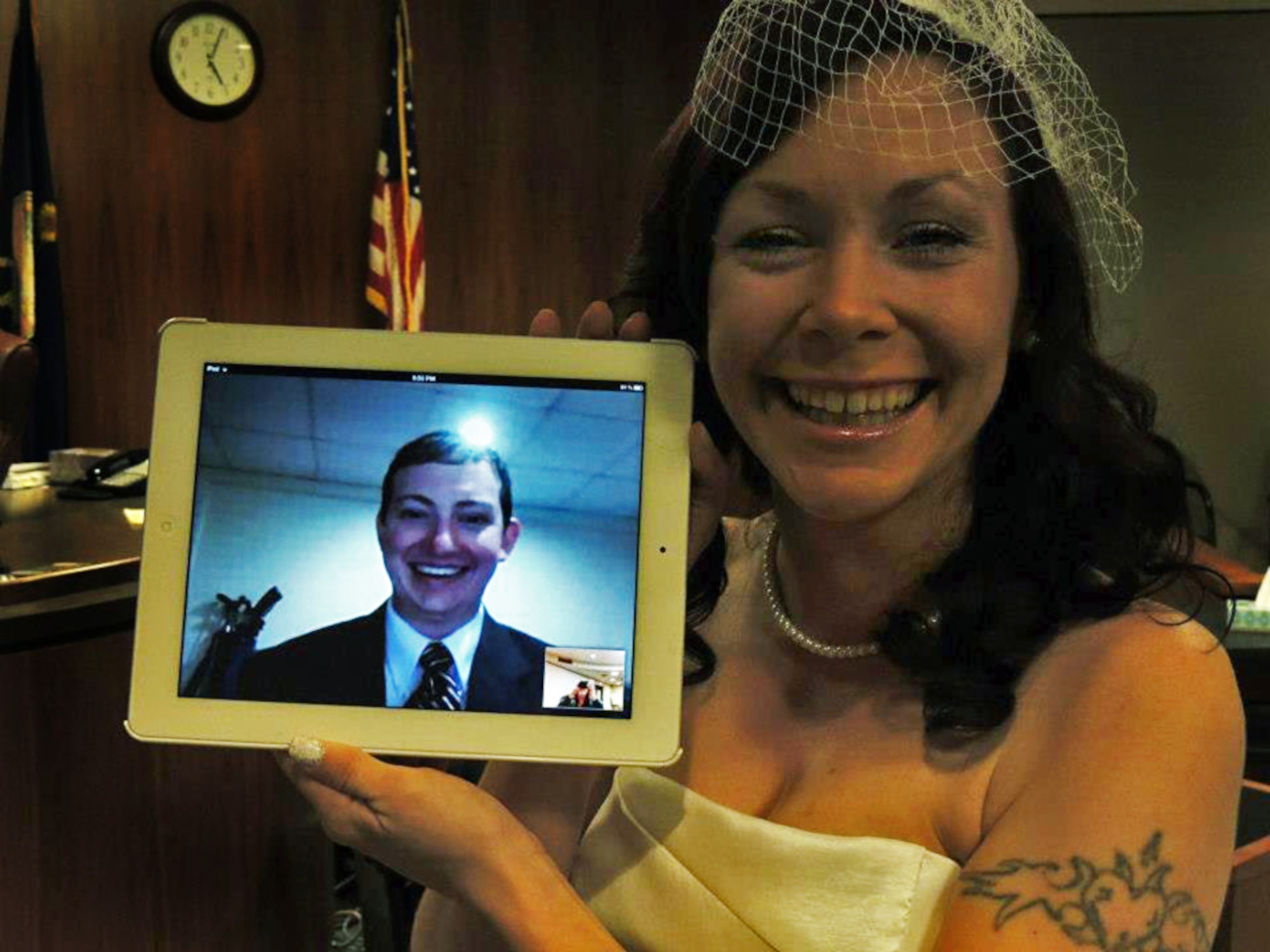 Kari Phelps, spouse of Senior Airman Daniel Phelps, 39th Air Base Wing Public Affairs photojournalist, holds a digital screen of her husband during their online wedding ceremony Oct. 29, 2012, at the Johnson County courthouse in Olathe, Kan. Airman Phelps was unable to attend the actual ceremony, due to being stationed at Turkey, so the couple connected virtually for their special day. (Courtesy photo/Released)

