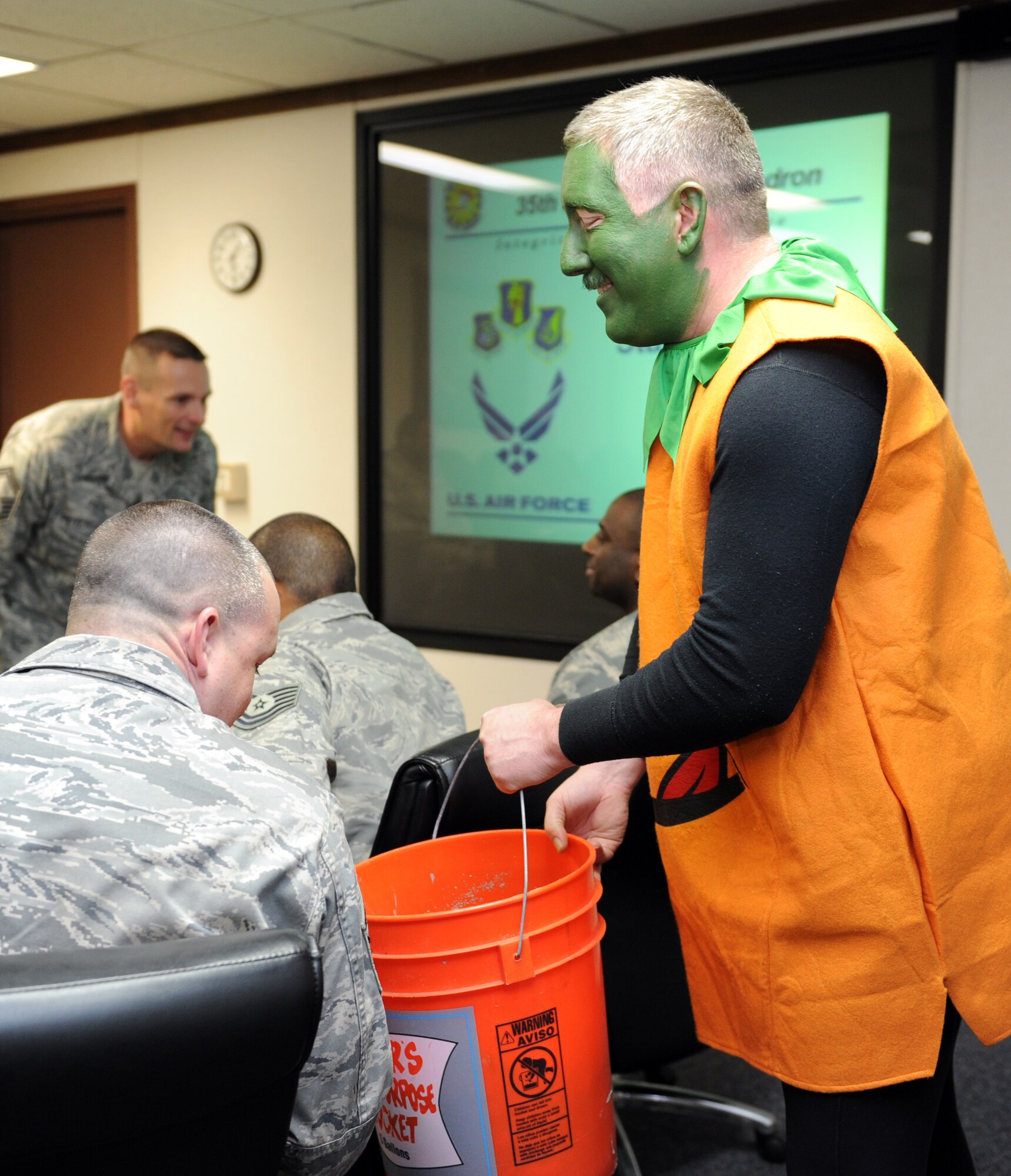 U.S. Air Force Chief Master Sgt. Kevin Lord, 35th Maintenance Squadron production superintendent, hands out candy during a staff meeting at Misawa Air Base, Japan, Oct. 31, 2012. Lord came in first for a Combined Federal Campaign fundraiser where the base voted for a chief master sergeant and a colonel they would like to see in a costume. All the proceeds from the fundraiser will go to the Family Support and Youth Programs here at Misawa. (U.S. Air Force photo by Airman 1st Class Kia Atkins)