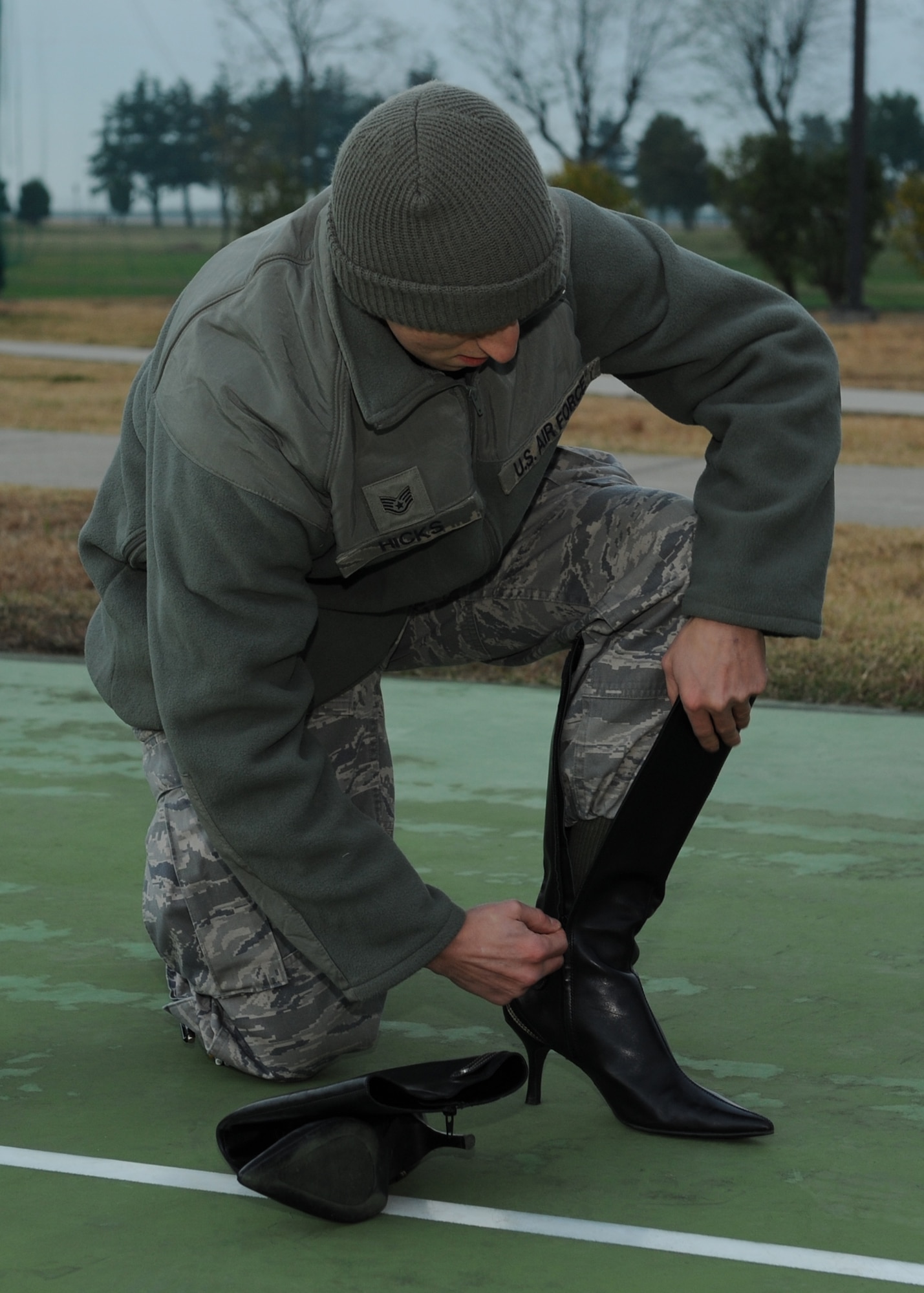 Staff Sgt. Brent Hicks, 8th Maintenance Squadron, puts on high-heeled boots in support of the Walk-A-Mile-In-Her-Shoes event on Kunsan Air Base, Republic of Korea, Oct. 31, 2012. The event was an effort to bring awareness to domestic violence and a push to end it. (U.S. Air Force photo/Staff Sgt. Jonathan Fowler)