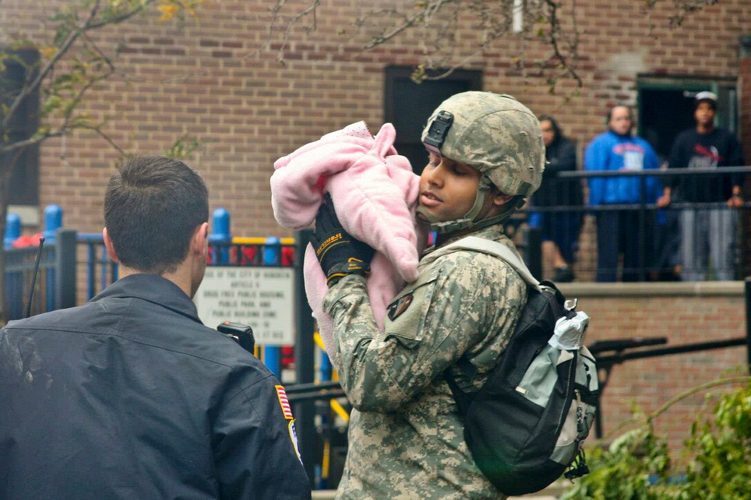 A soldier holds a child displaced by Hurricane Sandy in Hoboken, N.J., Oct. 31, 2012. The soldier is assigned to the New Jersey National Guard. 