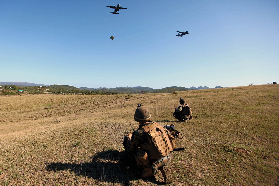 U.S. Marines watch as French Armed Forces aircraft drop supplies during Exercise Croix du Sud in Kumac, New Caledonia, Oct. 22. The U.S. Marines retrieved and transported the supplies to a battalion headquarters the French and U.S. Marines had set up for simulated disaster relief operations.  