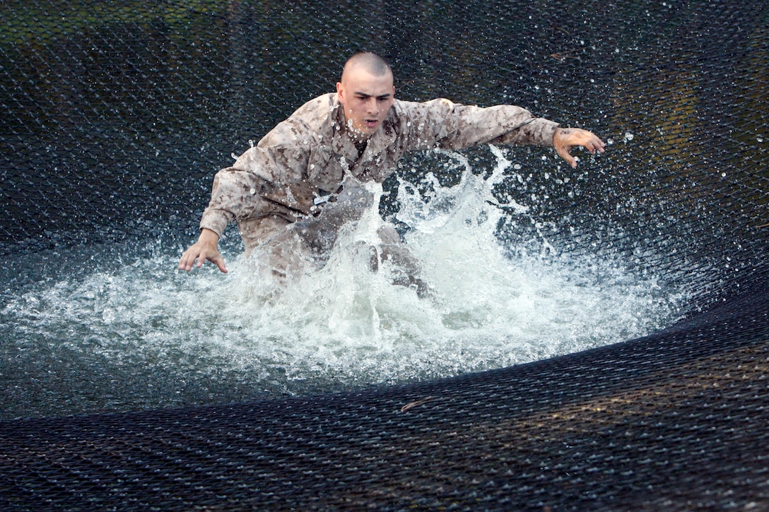 Rct. Michael Norman of Platoon 1094, Bravo Company, 1st Recruit Training Battalion, falls into the net on The Slide for Life on Parris Island on Sept. 25, 2012. The Slide For Life is a part of The Confidence Course designed to help recruits overcome fears and build confidence in their ability to complete recruit training. Norman, age 19, is a native of Hamburg, N.Y. 