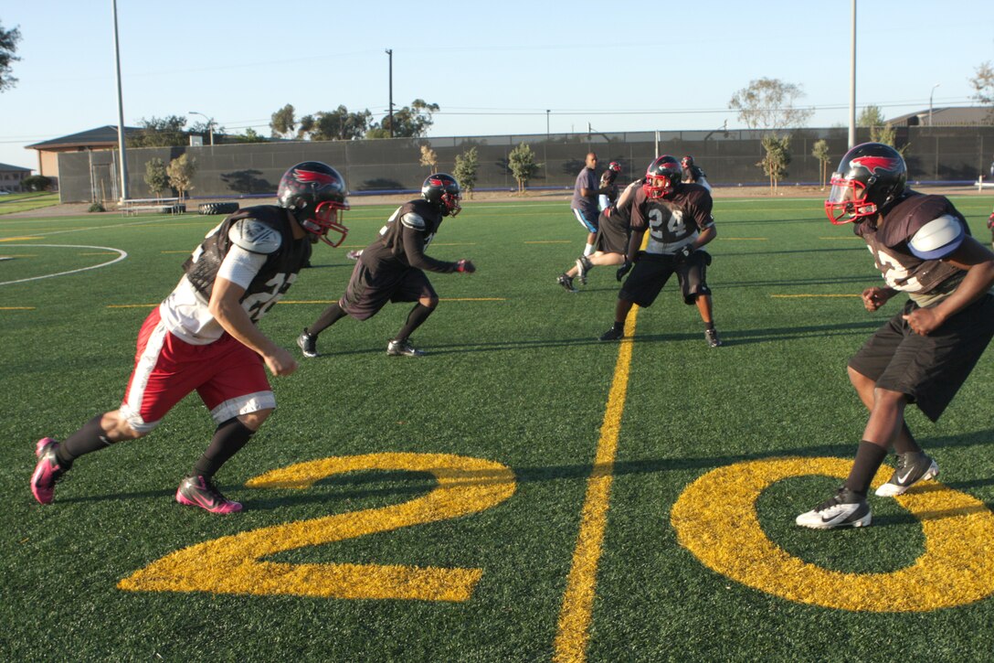 Players with the Marine Corps Air Station Miramar Falcons practice a defensive play at the practice football field aboard MCAS Miramar, Calif., Oct. 24. The Falcons have their first playoff game Oct. 30. 