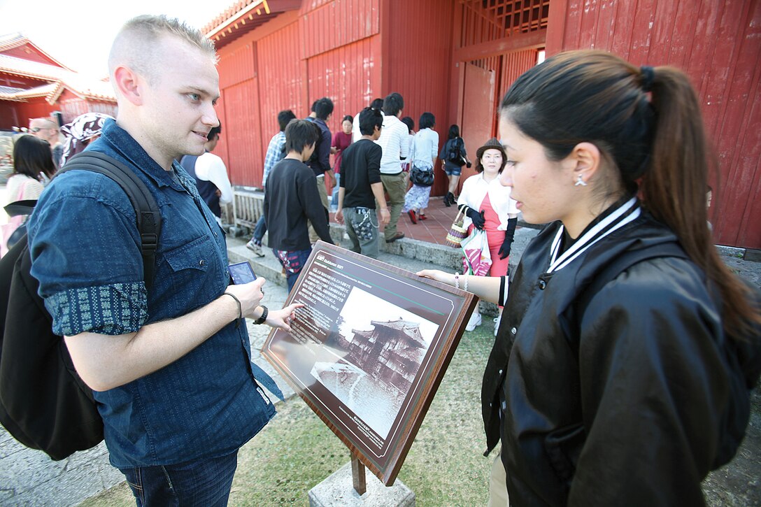 Erika Shinzato tells Seaman Edouard Blanc about the history of Shuri Castle during a tour of the castle Oct. 27. The tour gave the Marines and sailors a chance to learn more about the Okinawan culture and to interact with students from Naha Nikkei Business College. Shinzato is a second-year student at the college, and Blanc is a corpsman with Marine Medium Tiltrotor Squadron  265, Marine Aircraft Group 36, 1st Marine Aircraft Wing, III Marine Expeditionary Force. 