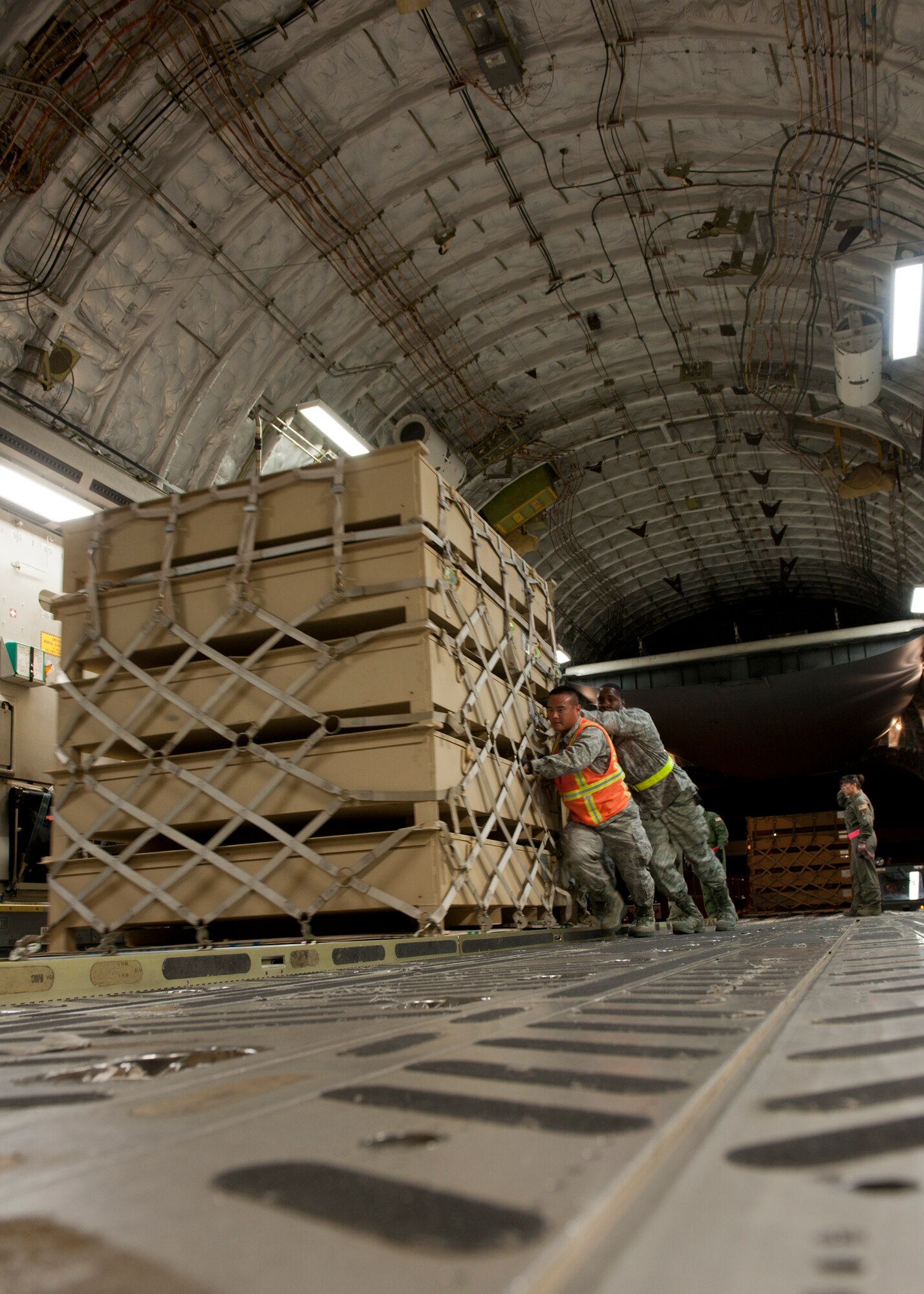 Personnel from the 49th Materiel Maintenance Squadron and the 89th Airlift Squadron load cargo onto a C-17 Globemaster III at Holloman Air Force Base, N.M., Nov. 2. The C-17 was here to pick up cargo that was packed by the 49th MMS. The 49th MMS was tasked with supporting the humanitarian relief efforts for the victims of Hurricane Sandy. In response to the tasking, the 49th MMS worked for 15 straight hours preparing more than 58,000 pounds of cargo spread across eight pallets. The cargo consisted of two water pumps capable of pumping 400 gallons of water per minute, 12,000 feet of hose, and two containers of system support items.  (U.S. Air Force photo by Senior Airman DeAndre Curtiss/Released)