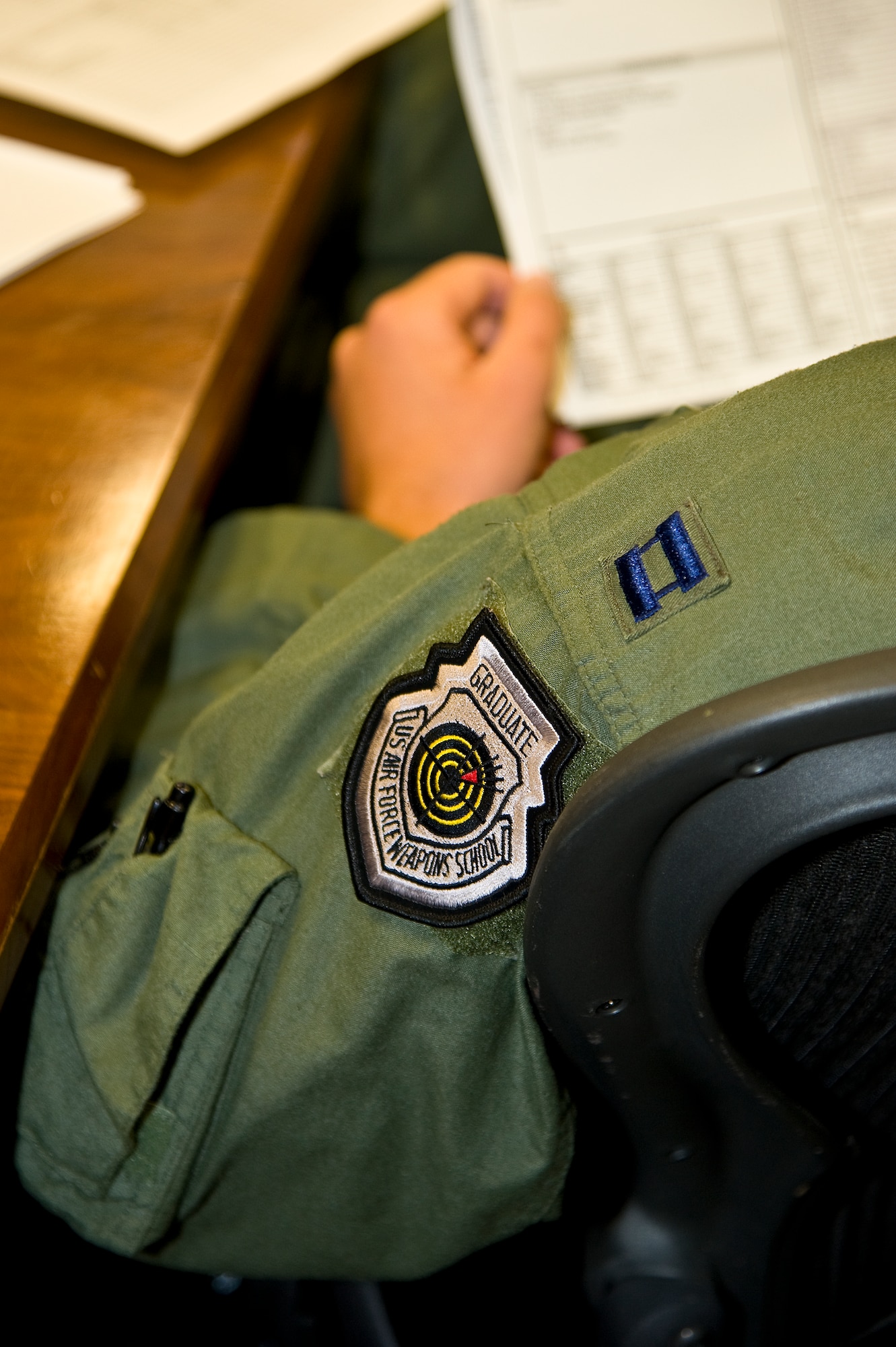 U.S. Air Force Capt. Matthew Prochazka, a MC-130H instructor navigator of 14th Weapons Squadron, wears a U.S. Air Force Weapons School patch while sitting at a mission brief for a training flight at Hurlburt Field, Fla., Oct. 11, 2012. The 14th WPSis the largest of three squadrons in the Weapons School that provide advanced training for special operations force operatiors. (U.S. Air Force Photo/Airman 1st Class Michelle Vickers)