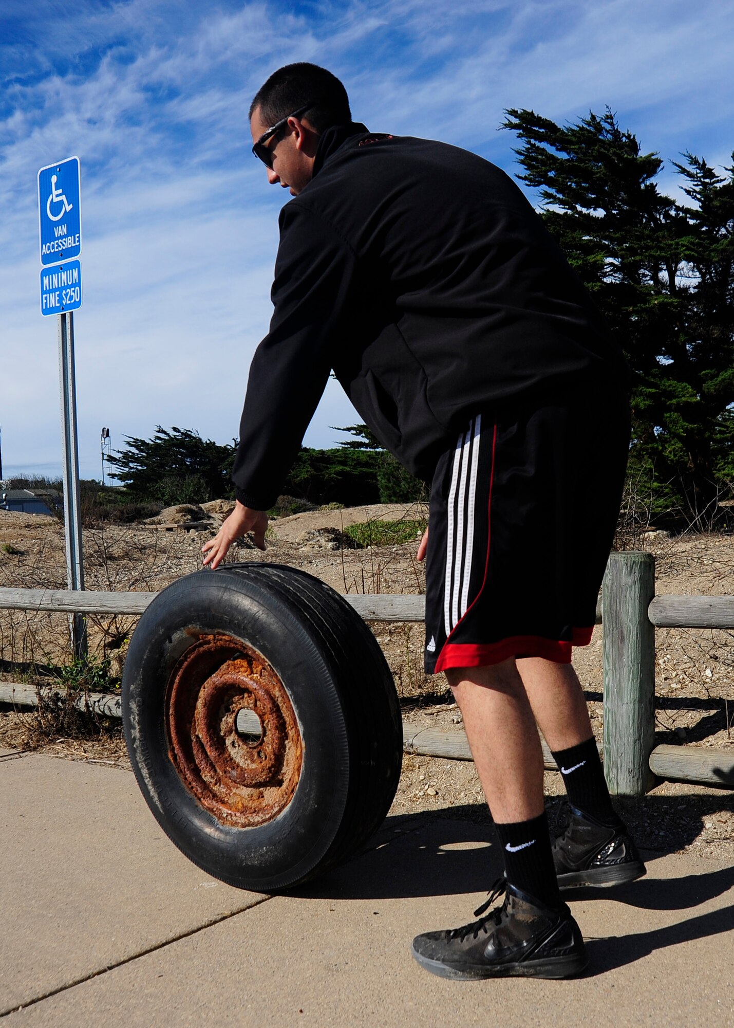 VANDENBERG AIR FORCE BASE, Calif. ? Airman First Class Patrick Moeslein, 30th Civil Engineering Squadron water and fuels systems apprentice, rolls a rusted out tire to a trash collection pile Thursday, Nov. 1, 2012. Moeslein was part of a volunteer group participating in the 2012 Beach Cleanup Day at Ocean Park on Vandenberg AFB. (U.S. Air Force Photo/Michael Peterson)