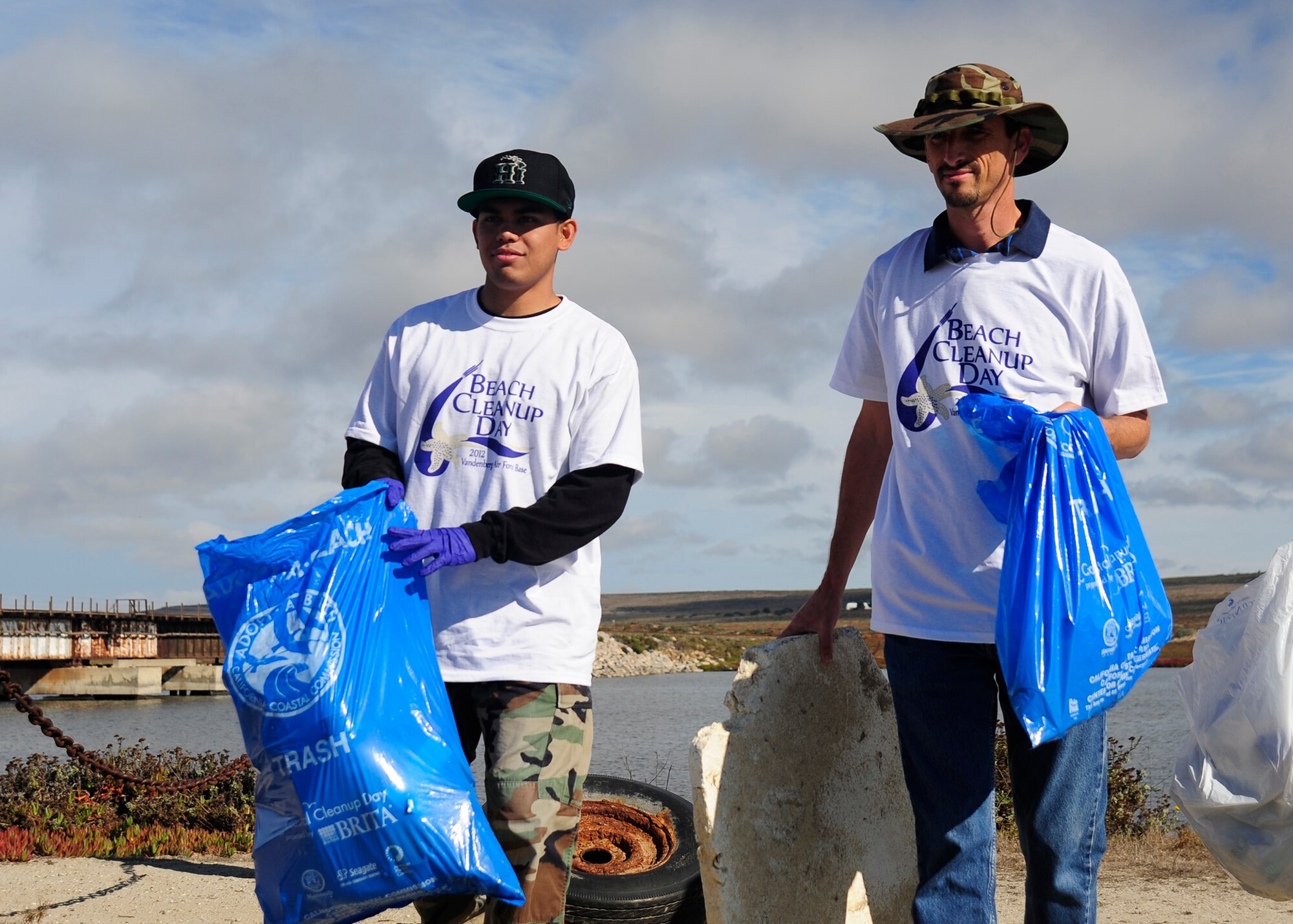 VANDENBERG AIR FORCE BASE, Calif. -- Senior Airman Larry Vince Mero, 30th Civil Engineer Squadron utilities member, and Adam Bray, Tetra Tech environmental engineer, haul bags of trash and recyclables to a collection pile Thursday, Nov. 1, 2012. Mero and Bray were part of a volunteer group participating in the 2012 Beach Cleanup Day at Ocean Park on Vandenberg AFB. (U.S. Air Force Photo/Michael Peterson)