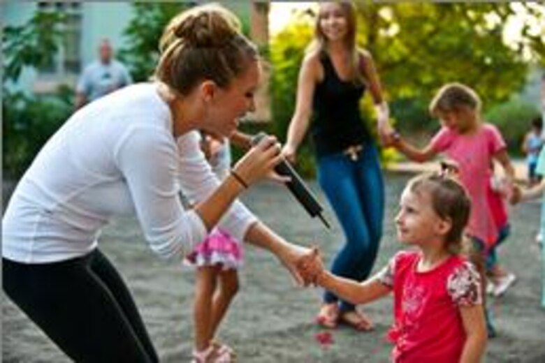 Staff Sgt. Samantha Renner sings to Shreeva, 4, at a performance at the Maevka House of Culture in Maevka Village, Kyrgyzstan. Renner volunteered to sing with the band for their final concert of their nine-day tour in Kyrgyzstan. Courtesy photo from AFCENT Band. 