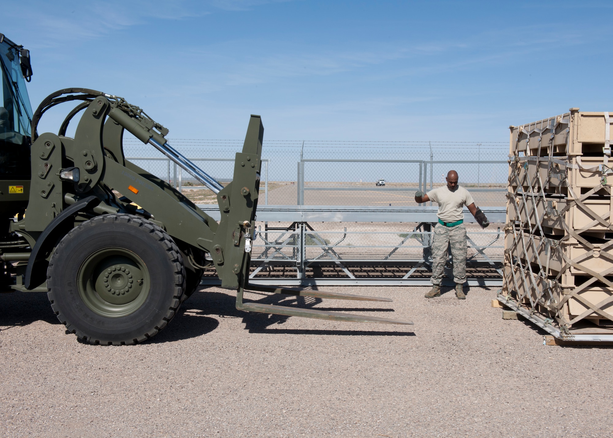 Senior Airman Ralph Steele, 49th Materiel Maintenance Squadron logistics planner, directs a forklift into position to pick up a pallet at Holloman Air Force Base, N.M., Nov. 2. The 49th MMS was tasked with supporting the humanitarian relief efforts for the victims of Hurricane Sandy. In response to the tasking, the 49th MMS worked for 15 straight hours preparing more than 58,000 pounds of cargo spread across eight pallets. The cargo consisted of two water pumps capable of pumping 400 gallons of water a minute, 12,000 feet of hose, and two containers of system support items. (U.S. Air Force photo by Senior Airman DeAndre Curtiss/Released)