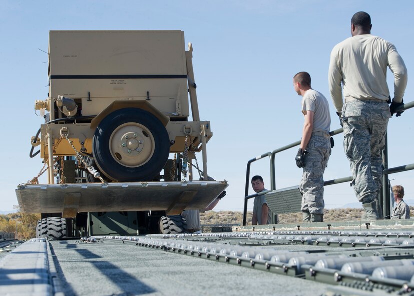 Personnel of the 49th Materiel Maintenance Squadron, load a pallet onto a 60,000-pound K-Loader using a forklift at Holloman Air Force Base, N.M., Nov. 2. The 49th MMS was tasked with supporting the humanitarian relief efforts for the victims of Hurricane Sandy. In response to the tasking, the 49th MMS worked for 15 straight hours preparing more than 58,000 pounds of cargo spread across eight pallets. The cargo consisted of two water pumps capable of pumping 400 gallons of water a minute, 12,000 feet of hose, and two containers of system support items. (U.S. Air Force photo by Senior Airman DeAndre Curtiss/Released)