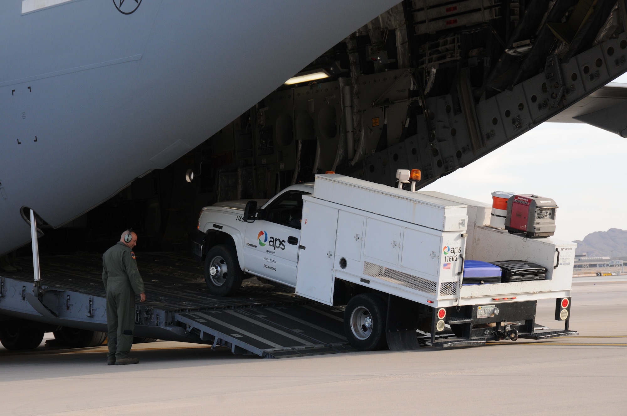 An Air Force loadmaster assigned to 445th Airlift Wing of the Air Force Reserve, load an Arizona Public Service utility vehicle onto a C-17 Globemaster III at the 161st Air Refueling Wing, Phoenix on November 2, 2012.  The 161st ARW will facilitate the loading and transportation of Salt River Project and Arizona Public Service line crews, support staff and required vehicles in efforts to restore power in the aftermath of Hurricane Sandy.   (U.S. Air Force photo by Master Sergeant Kelly Deitloff/Released)