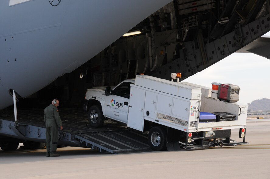 An Air Force loadmaster assigned to 445th Airlift Wing of the Air Force Reserve, load an Arizona Public Service utility vehicle onto a C-17 Globemaster III at the 161st Air Refueling Wing, Phoenix, Nov. 2, 2012. The 161st ARW will facilitate the loading and transportation of Salt River Project and Arizona Public Service line crews, support staff and required vehicles in efforts to restore power in the aftermath of Hurricane Sandy. (U.S. Air Force photo by Master Sgt. Kelly Deitloff/Released) 
