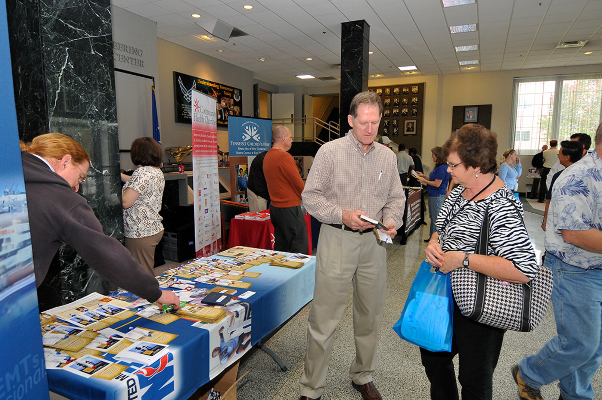 Strength for Service representative Larry Coppock explains their mission to Debra Taylor, a custodian with Premiere, Inc., during the CFC fair held recently at AEDC. (Photo by Jacqueline Cowan)