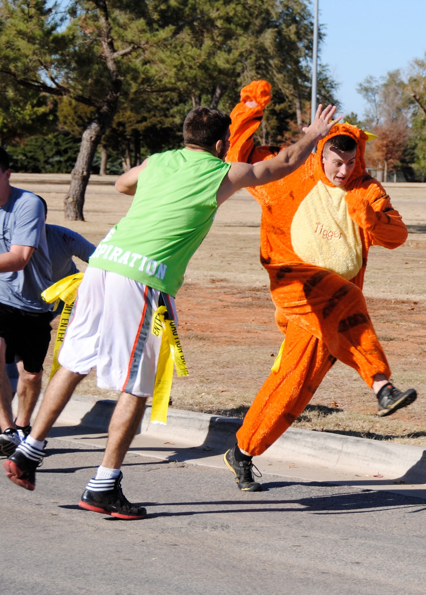 The zombie in the green shirt, Airman 1st Class Travis Swanson, with the 71st Operations Support Squadron, reaches for Airman 1st Class Steven “Tigger” Moxley, 71st Logistics Readiness Squadron, during the Zombie Fun Run 5K, Oct. 30, at Vance Air Force Base, Okla. (U.S. Air Force photo/ 2nd Lt. Ed Cortez)