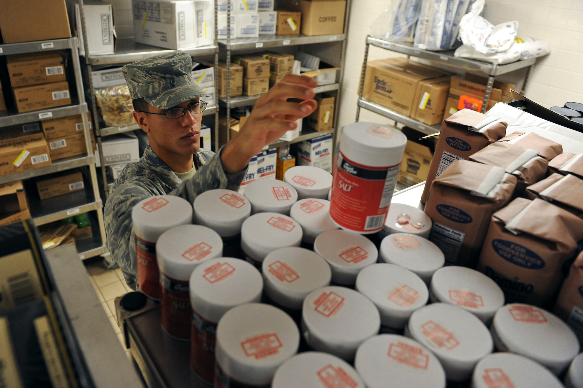 Airman 1st Class Jorge Garcia-Gonzalez, 2nd Force Support Squadron, reaches for a container of salt in the Red River Dining Facility on Barksdale Air Force Base, La., Oct. 31. At the end of each month, an inventory of all the food is conducted to make sure everything is accounted for. (U.S. Air Force photo/Senior Airman Micaiah Anthony)(RELEASED)
