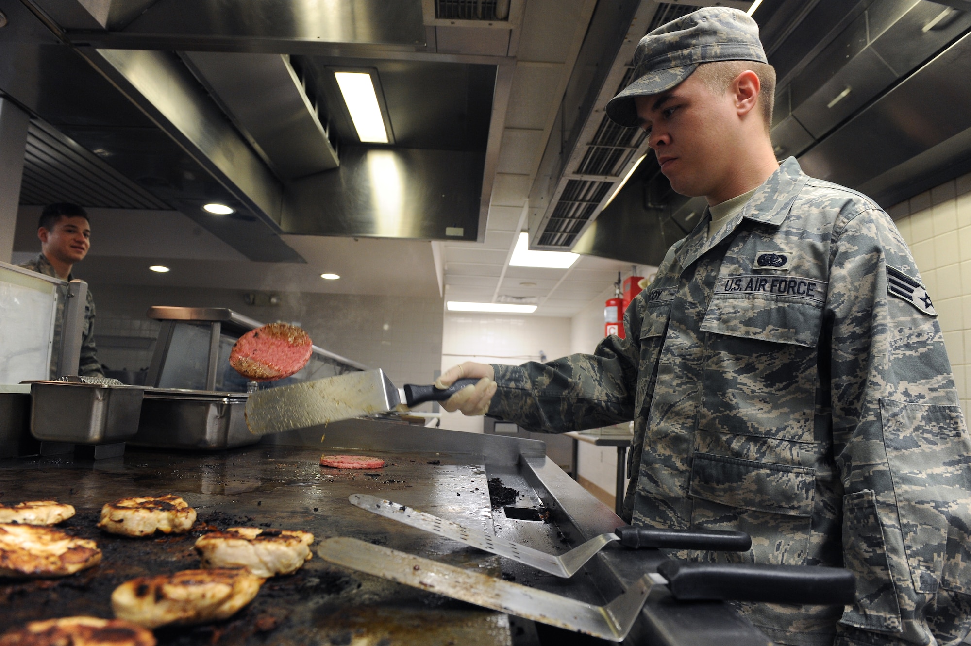 Senior Airman Barry McCoy, 2nd Force Support Squadron, flips a burger in the Red River Dining Facility on Barksdale Air Force Base, La., Oct. 31. The Red River Dining Facility offers a wide variety of food for Team Barksdale to enjoy. The dining facilities service hours for breakfast are from 6 a.m. to 8 a.m., lunch is served from 11 a.m. to 1 p.m., dinner is served from 5 p.m. to 7 p.m. and midnight dining hours are from 10:30 p.m. to 1 a.m. (U.S. Air Force photo/Senior Airman Micaiah Anthony)(RELEASED)