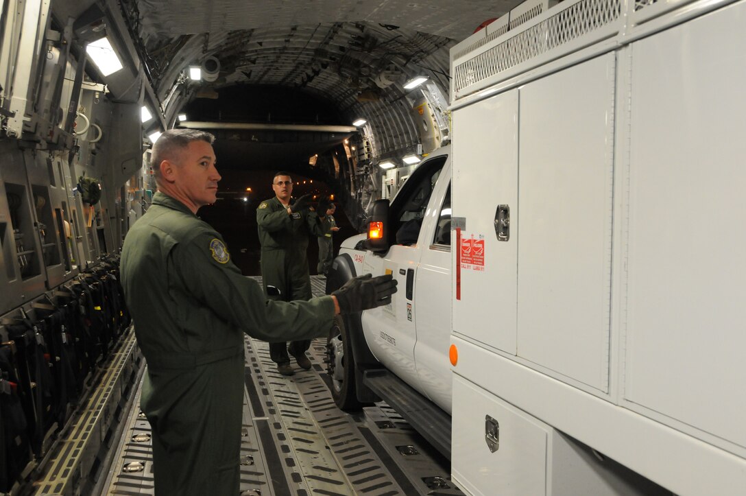 WRIGHT-PATTERSON AIR FORCE BASE, Ohio - 445th Airlift Wing reservists Master Sgts. Brian Dawes (foreground) and Jerry Cremmens, loadmasters from the 89th Airlift Squadron, guide a Southern California Edison utility company vehicle into the cargo area of a 445 AW C-17 Globemaster III at March Air Reserve Base, Calif., Nov. 1. The wing moved five utility trucks and 26 personnel from March ARB to Stewart Air National Guard Base, Newburgh, N.Y., in support of the humanitarian relief efforts to restore power to the areas affected by Hurricane Sandy. (U.S. Air Force photo/Tech. Sgt. Anthony Springer) 