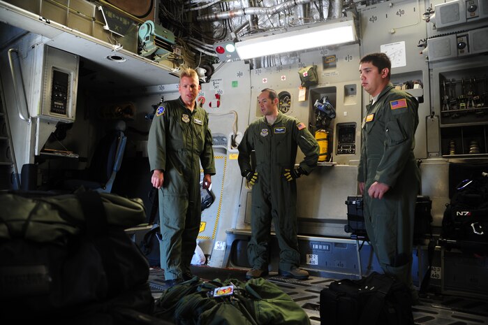 Maj. Sebastian De Mitz, 14th Airlift Squadron German pilot, receives a brief from loadmasters Airman 1st Class Dwayne Baldwin, 16th Airlift Squadron, and Staff Sgt. Robert Strecker, 14th Airlift Squadron, on the status of pre-flight checks before takeoff Nov. 1, 2012,  at Joint Base Charleston – Air Base, S.C. The aircrew was dispatched to pick up supplies and cadaver teams to deliver them to assist with the relief efforts for Hurricane Sandy affecting the Northeast. (U.S. Air Force photo /Staff Sgt. Rasheen Douglas)