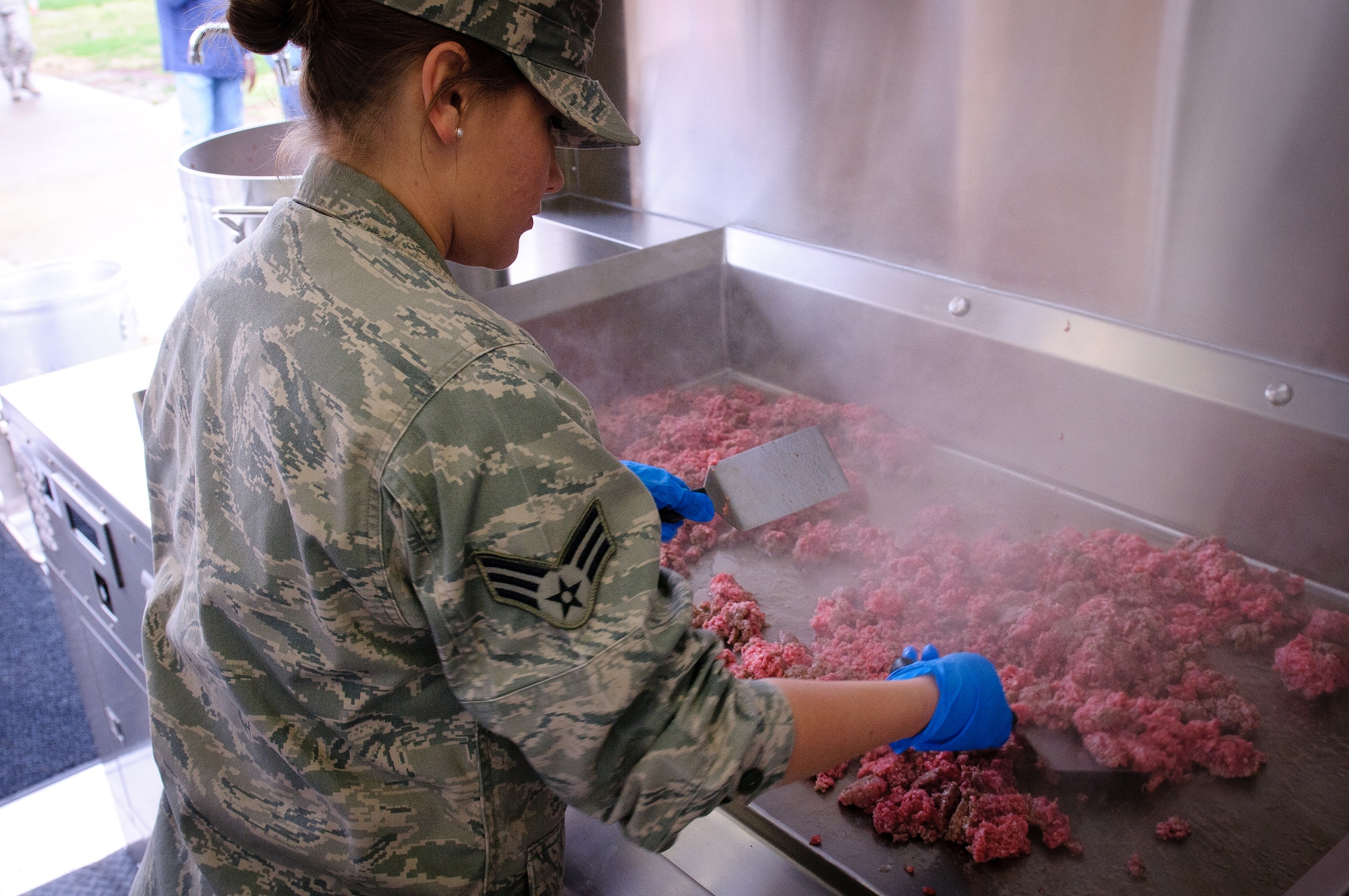 Senior Airman Shelby Basham of the 123rd Force Support Squadron cooks ground beef for spaghetti sauce during training on a new field kitchen at the Kentucky Air National Guard Base in Louisville, Ky., on March 16, 2012. The kitchen can be deployed to the site of a natural disaster to provide hot meals for relief workers. (U.S. Air Force photo by Senior Airman Maxwell Rechel)