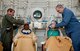 Lt. Col. (Dr.) Michael Richards and Tech. Sgt Christain Simpson help patients attach oxygen-providing hoods prior to a dive in the hyperbaric chamber at David Grant Medical Center. (U.S. Air Force Photo/Ken Wright)