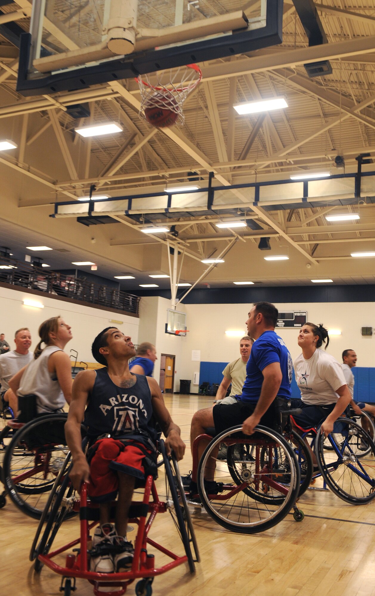 Members of the Desert Lightning Team and members from the University of Arizona adaptive athletics program watch as the ball goes through the hoop in a game of wheelchair basketball during an adaptive sporting demonstration at the Benko Fitness Center on Davis-Monthan Air Force Base Oct. 30. The U of A's adaptive athletics program is the largest and most successful program of its kind in the country. (U.S. Air Force photo by Senior Airman Brittany Dowdle/released)