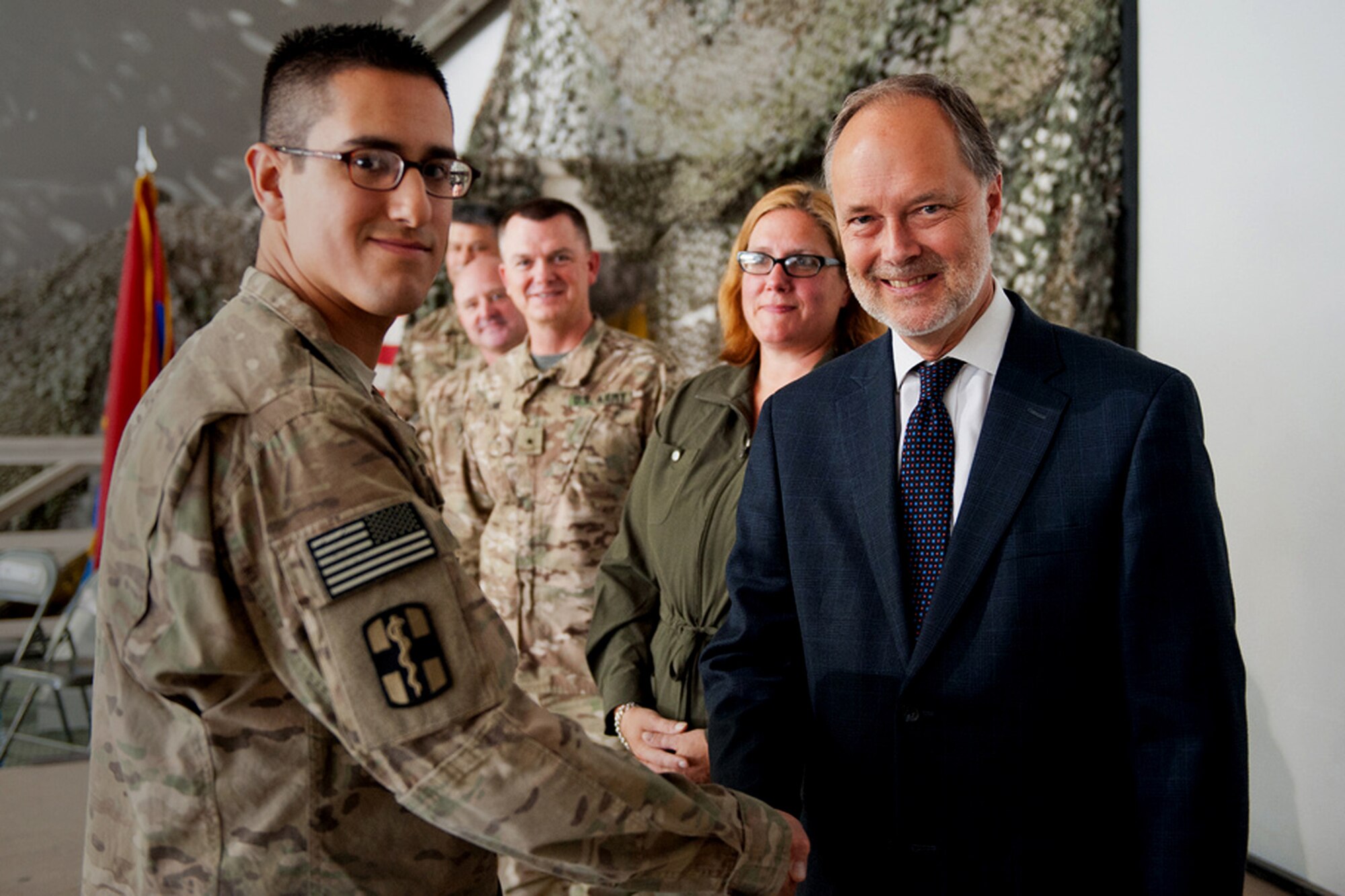 U.S. Air Force Senior Airman Edgar Munoz-Lopez, assigned to 455th Expeditionary Medical Operations Squadron, shakes hands with the Honorable James Cunningham, U.S. Ambassador to Afghanistan, after taking an oath of U.S. citizenship during a naturalization ceremony at Bagram Airfield, Afghanistan, Nov. 2. Cunningham thanked servicemembers for their service. 31 members of the U.S. Armed Forces took the oath, to include, Army, Air Force, and Marines. (U.S. Army Photo/SGT Roland Hale)