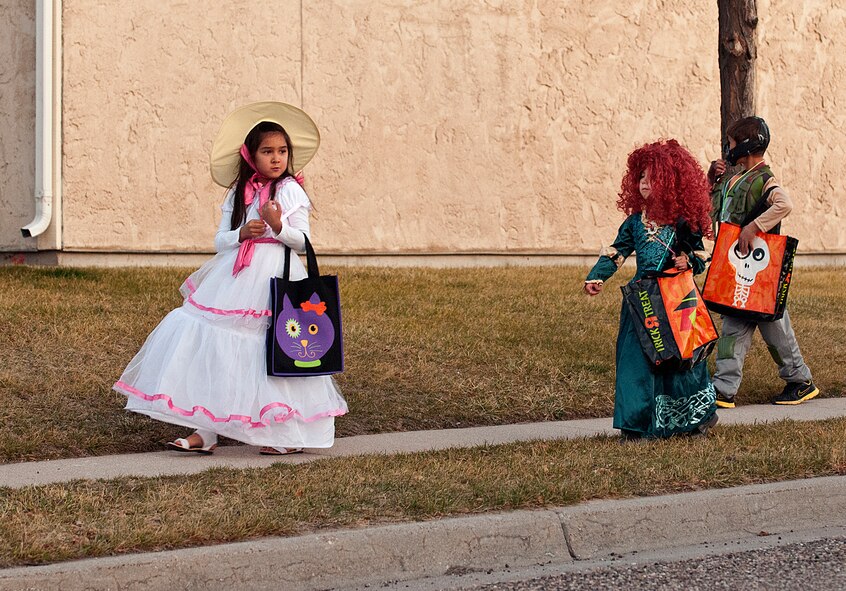 Madison Withey, 7, daughter of Staff Sgt. Aaron Withey, 90th Security Support Squadron, leads her friends Hailey Lavallie, 6, and Samual Lavallie, 8, as they trick-or-treat along Peacekeeper Road in F.E. Warren Air Force Base housing on Halloween. (U.S. Air Force photo by R.J. Oriez)