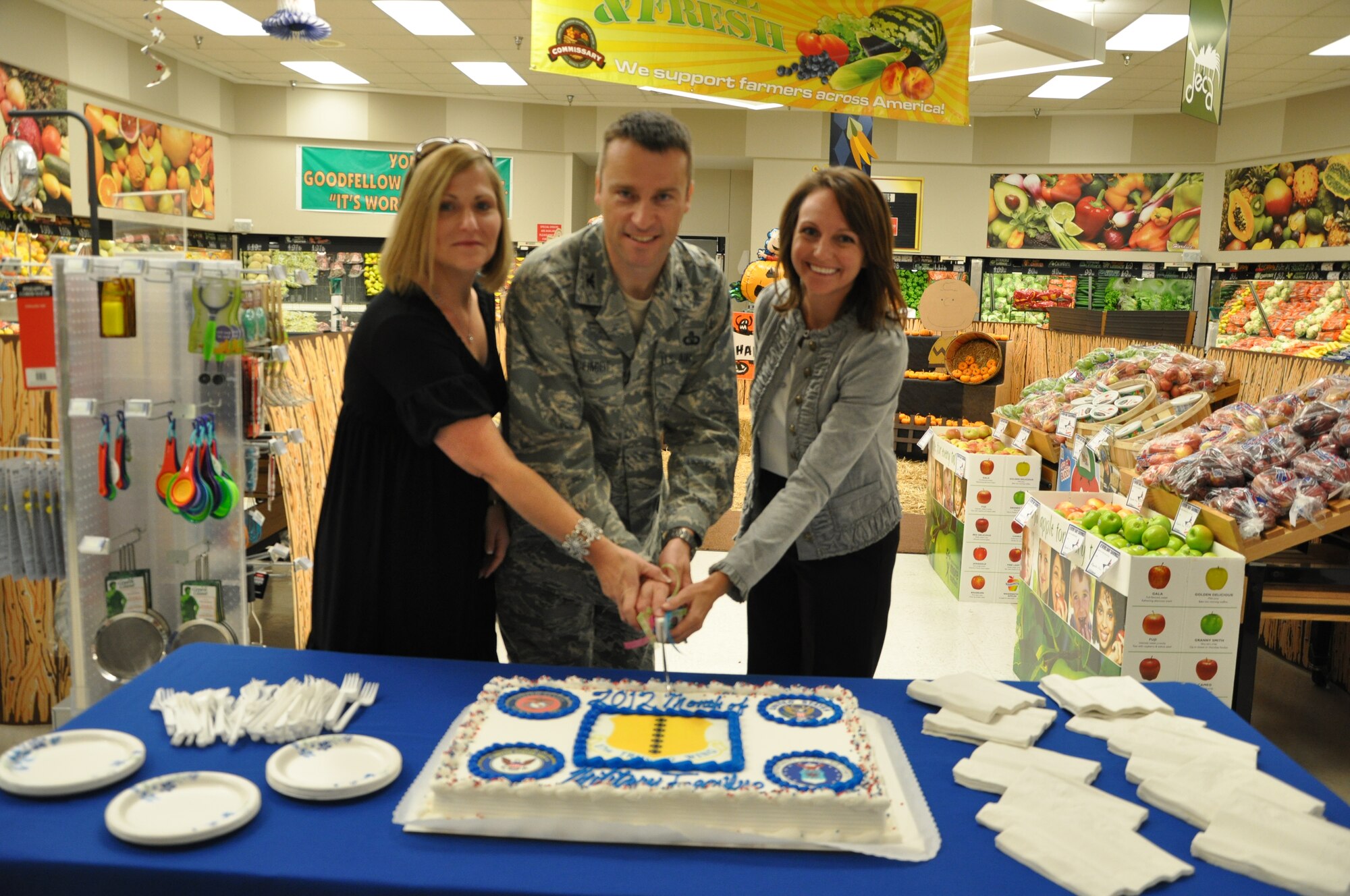 GOODFELLOW AIR FORCE BASE, Texas- From the left, Kim Schmidt, Col. Thomas Schmidt, 17th Training Wing Vice Commander, and Ellery Damiano cut a cake at the Month of Military Family kick-off at the base commissary Nov. 1 here. The month honoring military families is schedule to have various events and activities for families to enjoy. (U.S. Air Force photo/ Airman 1st Class Erica Rodriguez)