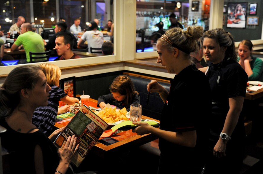 U.S. Navy Seaman Jordan Branch master at arms 3rd class, participates in a Tip-A-Cop event to help raise funds for the Kadena Special Olympics by helping the the employee's workload at Chili's on Kadena Air Base, Japan, Nov. 2, 2012. The KSO began in 2000 with approximately 400 athletes and 600 volunteers as an 18th Wing community goodwill initiative to strengthen U.S. - Okinawa relationships.. (U.S. Air Force photo/Airman 1st Class Justin Veazie)