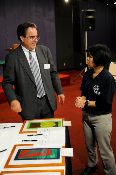 Alfred Magleby, consul general, speaks with Sayaka Kawatake, 18th Wing Public Affairs community relations specialist, about different pieces of the artwork that were displayed at the Kadena Special Olympics Art Auction on Okinawa, Japan, Nov.2, 2012. The KSO is a one-day sporting and entertainment event with more than 870 special needs athletes and artists participating in competitions, music events and special recognition ceremonies. (U.S. Air Force photo/Airman 1st Class Justin Veazie)