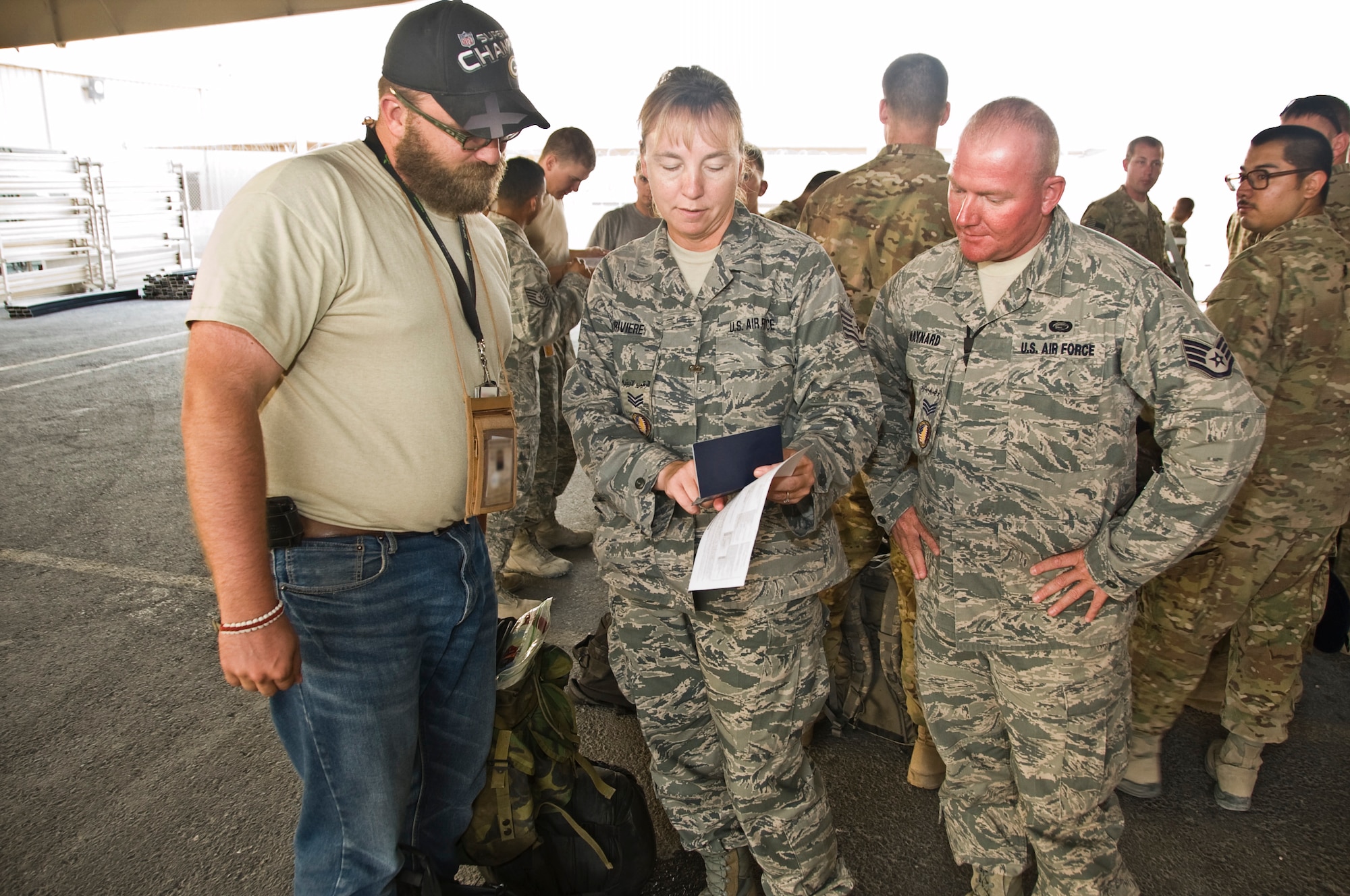 Tech. Sgt. Barbara Lariviere and Staff Sgt. Shane Maynard, 379th Host Nation Coordination Cell liaison officers, ensure passengers have the correct paperwork before processing through immigrations and customs. HNCC serves as the liaison between U.S. Armed Forces and the host nation concerning a multitude of significant matters to include immigrations, customs, current operations and diplomatic clearances. (U.S. Air Force photo/Senior Airman Bryan Swink)