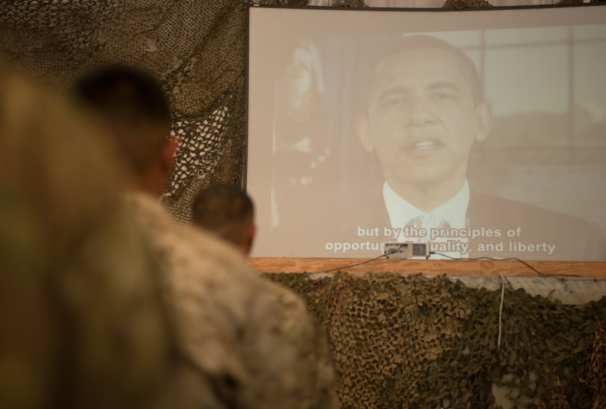 Members of the U.S. Armed Forces watch a video of U.S. President Barrack Obama as he congratulates them on becoming U.S. citizens during a naturalization ceremony at Bagram Airfield, Nov. 2, 2012. 31 members from the Army, Air Force and Marines swore an oath of U.S. citizenship. The Honorable James Cunningham, U.S. Ambassador to Afghanistan, presented the servicemembers with their citizenship certificates. (U.S. Air Force photo/Staff Sgt. Jeff Nevison)