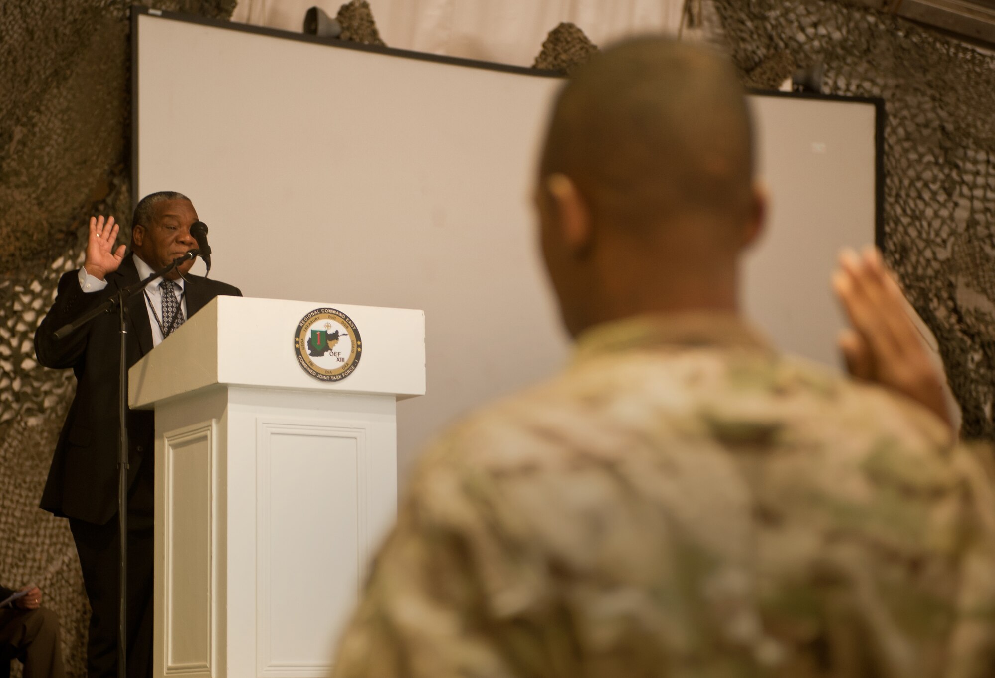 Mr. Elvis Quiles, a member of the U.S. State Department, administers the oath of U.S. citizenship to 31 U.S. servicemembers during a naturalization ceremony at Bagram Airfield, Afghanistan, Nov. 2, 2012. Those servicemembers were from the Army, Air Force, and Marines. The Honorable James Cunningham, U.S. Ambassador to Afghanistan, presented the servicemembers with their citizenship certificates. (U.S. Air Force photo/Staff Sgt. Jeff Nevison)