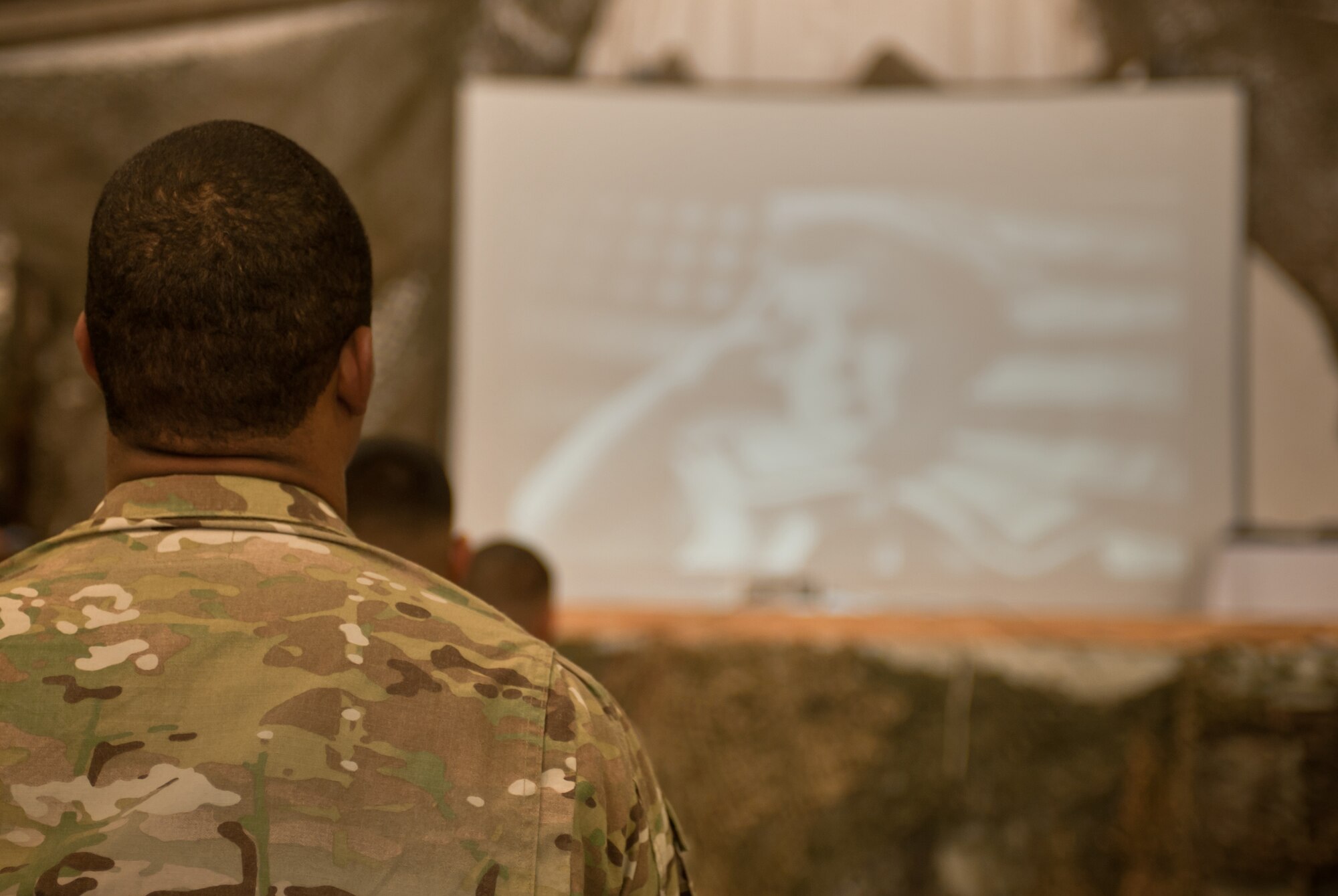 A U.S. servicemember watches a video of U.S. citizenship as he waits to take the oath during a naturalization ceremony at Bargam Airfield, Afghanistan, Nov. 2, 2012. 31 members of the U.S. Armed Forces took the oath of citizen, to include Army, Air Force, and Marines. The Honorable James Cunningham, U.S. Ambassador to Afghanistan, presented the servicemembers with their citizenship certificates. (U.S. Air Force photo/Staff Sgt. Jeff Nevison)