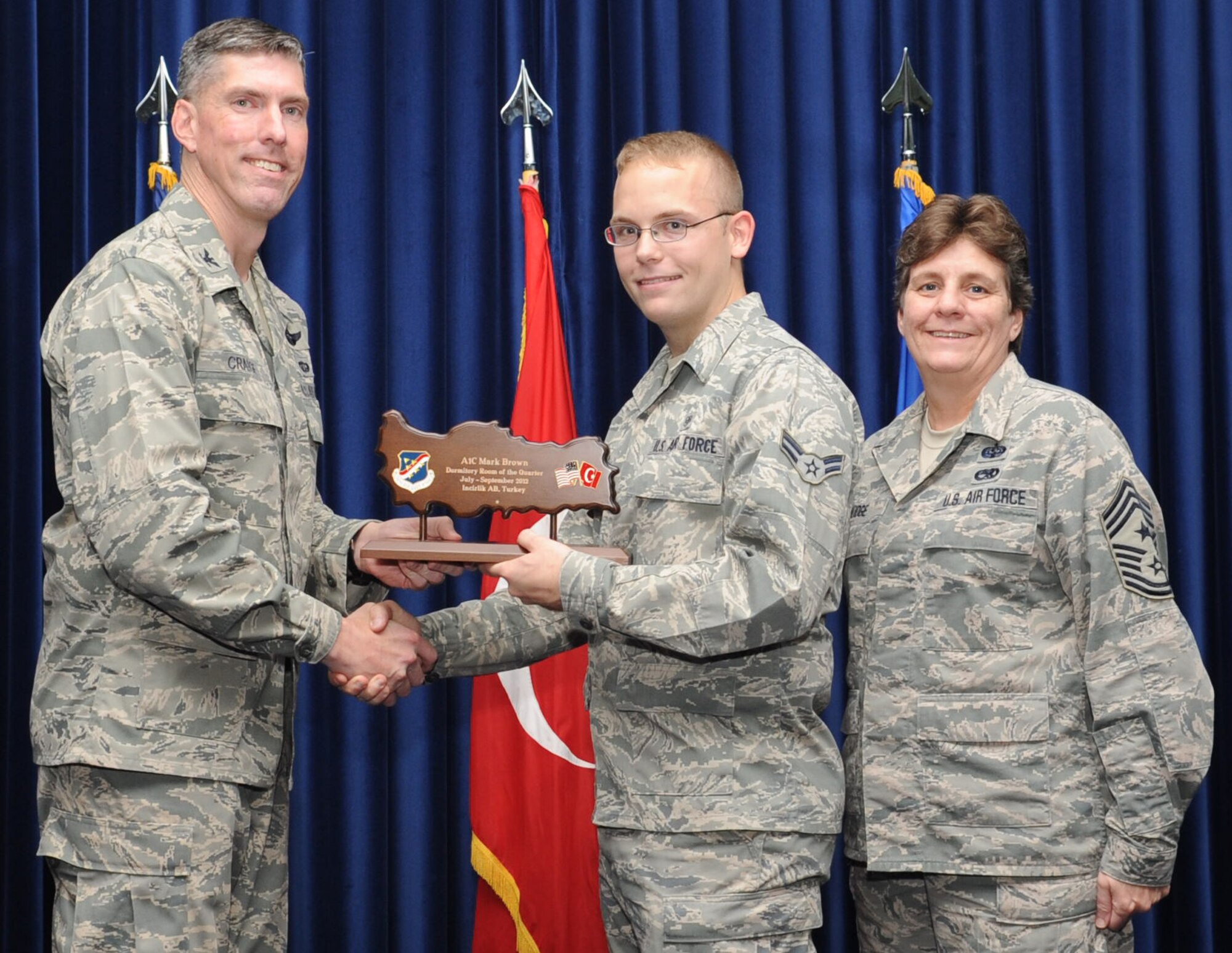 Airman 1st Class Mark Brown, 39th Medical Support Squardon, is presented a Dormitory Room of the Quarter Award at the club complex ballroom Oct. 31, 2012 at Incirlik Air Base, Turkey. Quarterly award and promotion ceremonies are a time-honored tradition across all branches of the armed forces. (U.S. Air Force photo by Senior Airman Daniel Phelps/ Released)