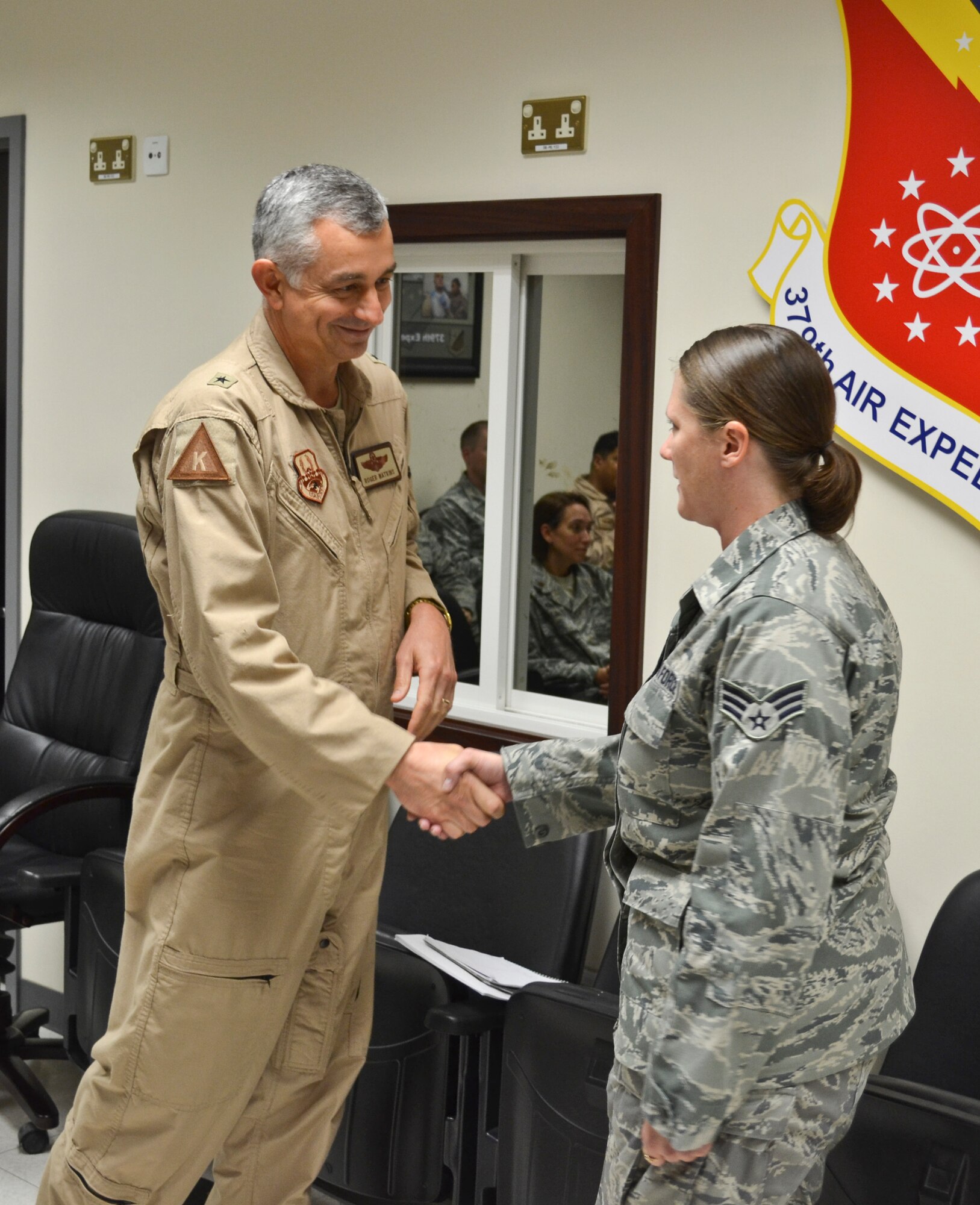 Brig. Gen. Roger Watkins, 379th Air Expeditionary Wing commander, recognizes and coins Senior Airman Kimberly Robinson during a wing staff meeting Oct. 26, 2012. She is a 379th Aircrew Flight Equipment C-130 Hercules technician who was recently named the 2011 Outstanding U.S. Air Force Air Reserve Component Aircrew Flight Equipment Airman of the Year as a result of her accomplishments while stationed with the 911th Operations Support Squadron, Pittsburgh Air Reserve Station, Pa. (U.S. Air Force photo/Senior Airman Bryan Swink)