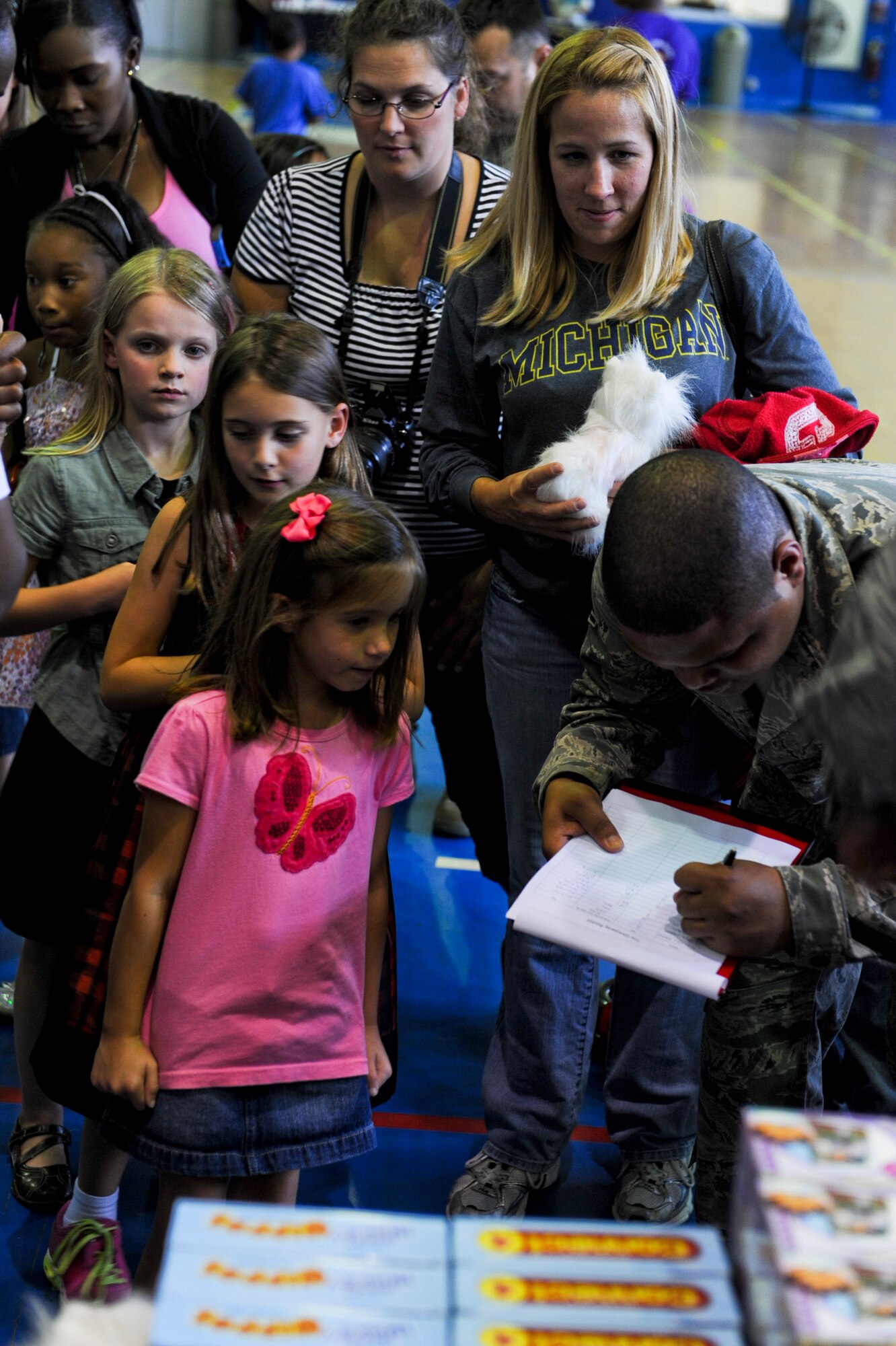 Participants tell their name and age to a volunteer before receiving their free toy during the Play Comforts Toy Giveaway at the Kadena Teen Center on Kadena Air Base, Japan, Nov. 2, 2012. Play Comforts Toy Giveaway is an international event and it was the first year that Kadena was selected. (U.S. Air Force photo/Airman 1st Class Justin Veazie)